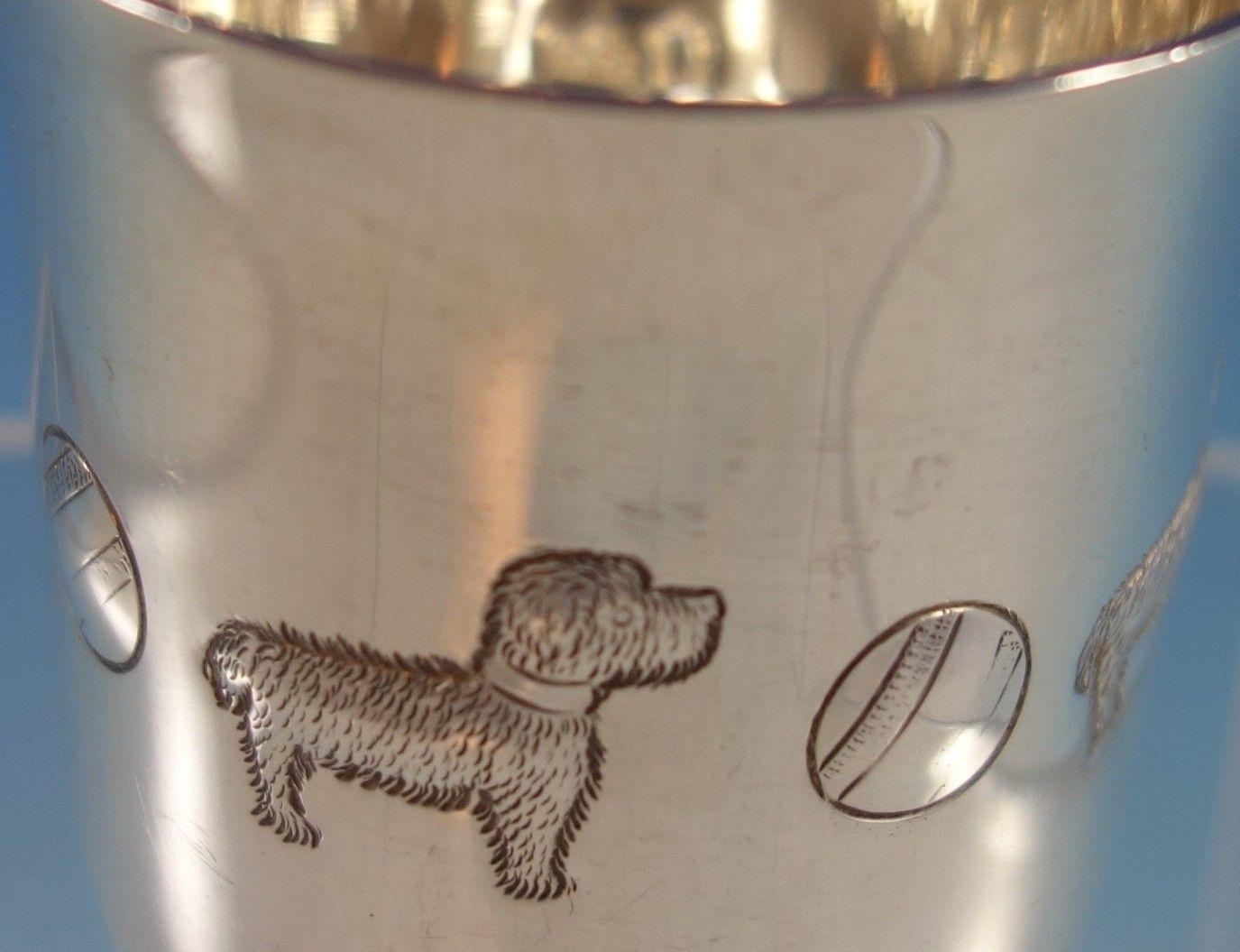 This adorable sterling baby cup was made by Tiffany & Co. It is hand chased featuring dogs and balls. The measurements for the cup are 2 1/4