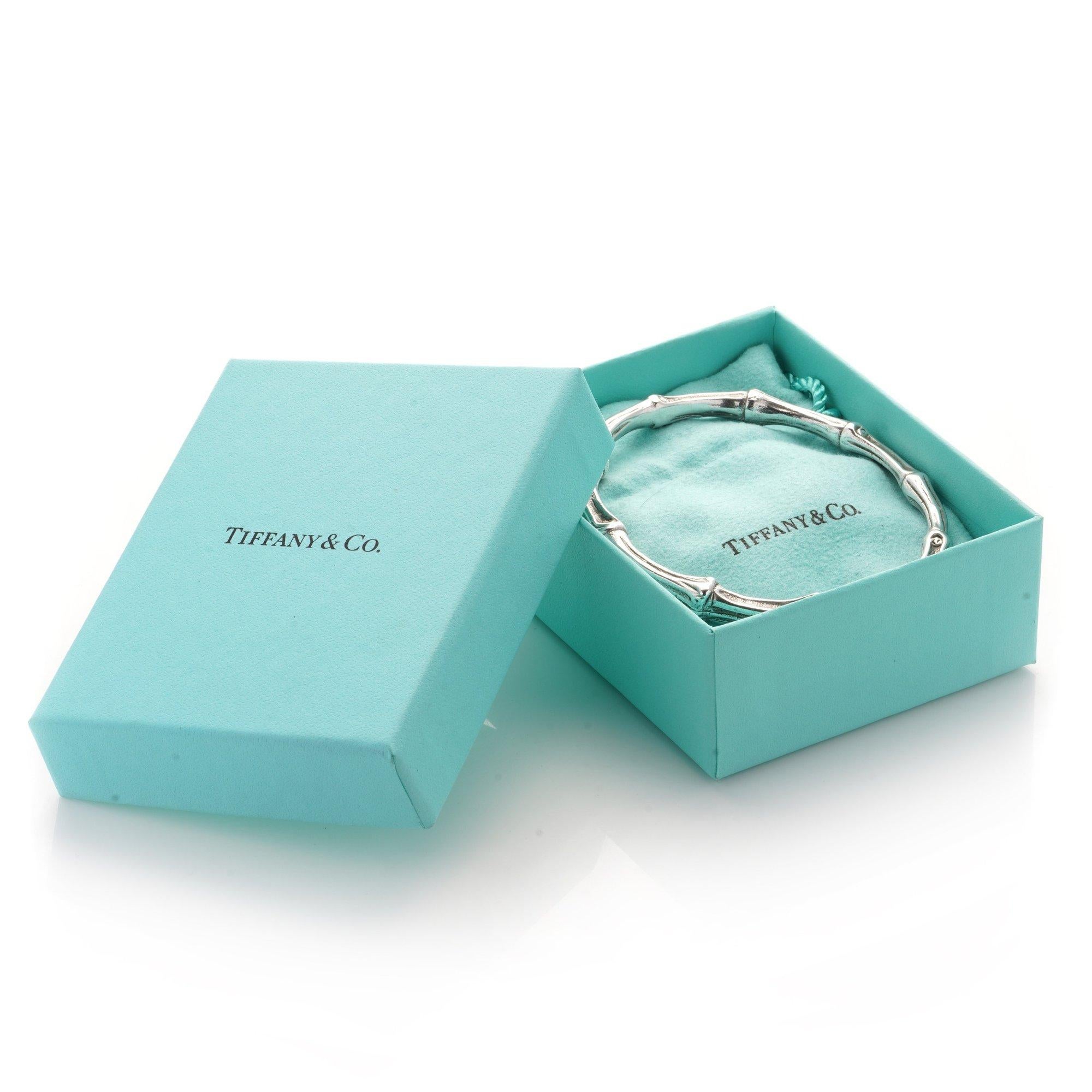 Tiffany & Co. sterling silver bangle in the shape of bamboo.
Made London 1996
Fully hallmarked sterling silver and Tiffany & Co.

Comes in original box and travel pouch.

Dimensions -
Length x width: 7.7 x 7.3 cm
Weight: 46 grams

Condition: Bangle