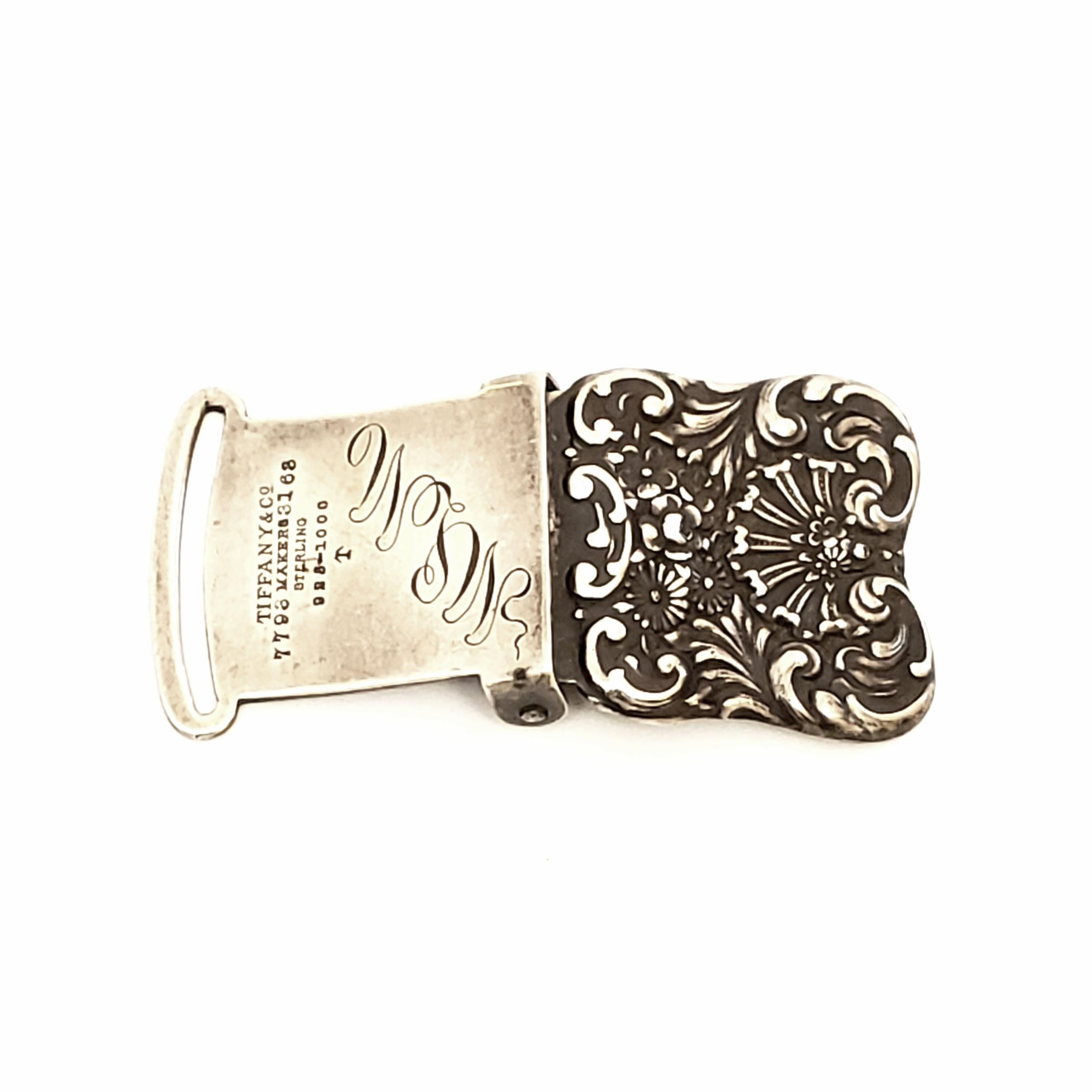 Small square sterling silver sash/belt buckle by Tiffany & Co, circa 1892-1902.

Beautiful chased and respousse design with floral and scroll patterns. Made under the directorship of Charles L. Tiffany. 

Monogram appears to be MLM

Measures 1 1/8