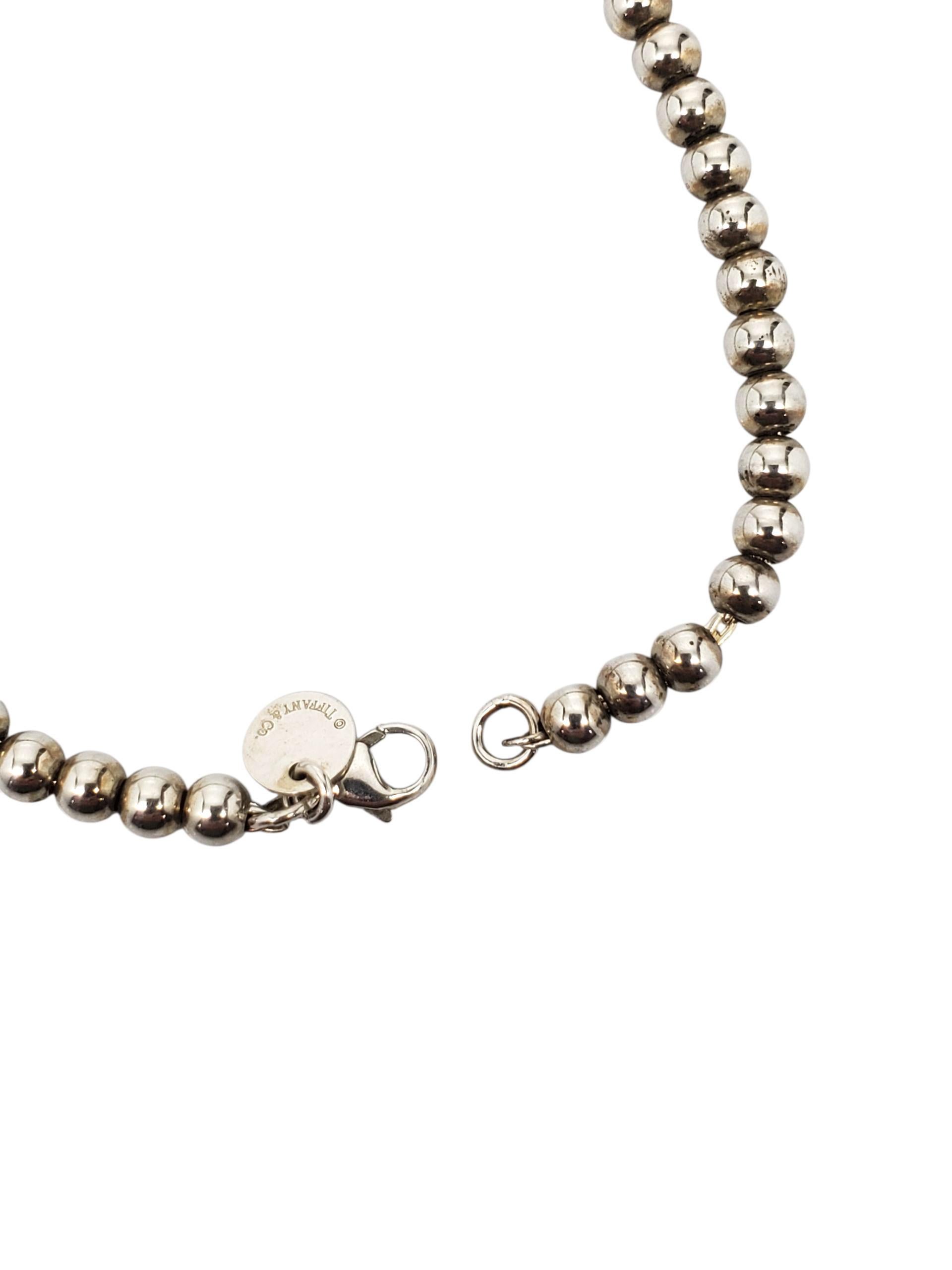 Tiffany & Co. Bracciale con perline a forma di cuore in argento blu smaltato - A. Silver

Questo autentico braccialetto di perline in argento Tiffany & Co. è caratterizzato dal ciondolo a cuore con smalto blu Tiffany 