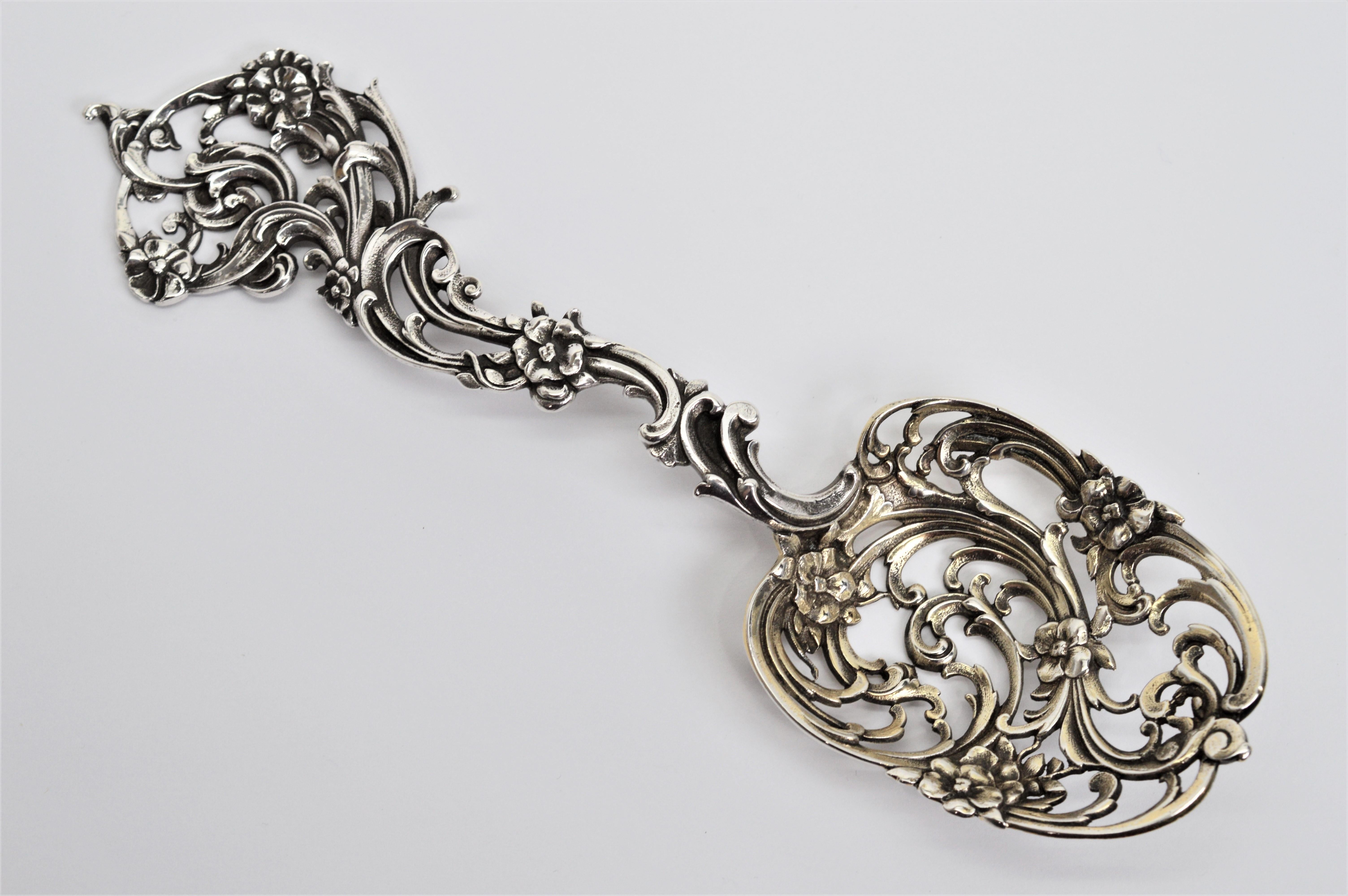 Beautifully hand pierced and chased with an intricate floral pattern, this Tiffany & Co. sterling silver bon bon spoon is a sweet accent for your serving table. Perfect for dessert, fruit or nuts, this serving spoon measures 7-1/2 inches in length.