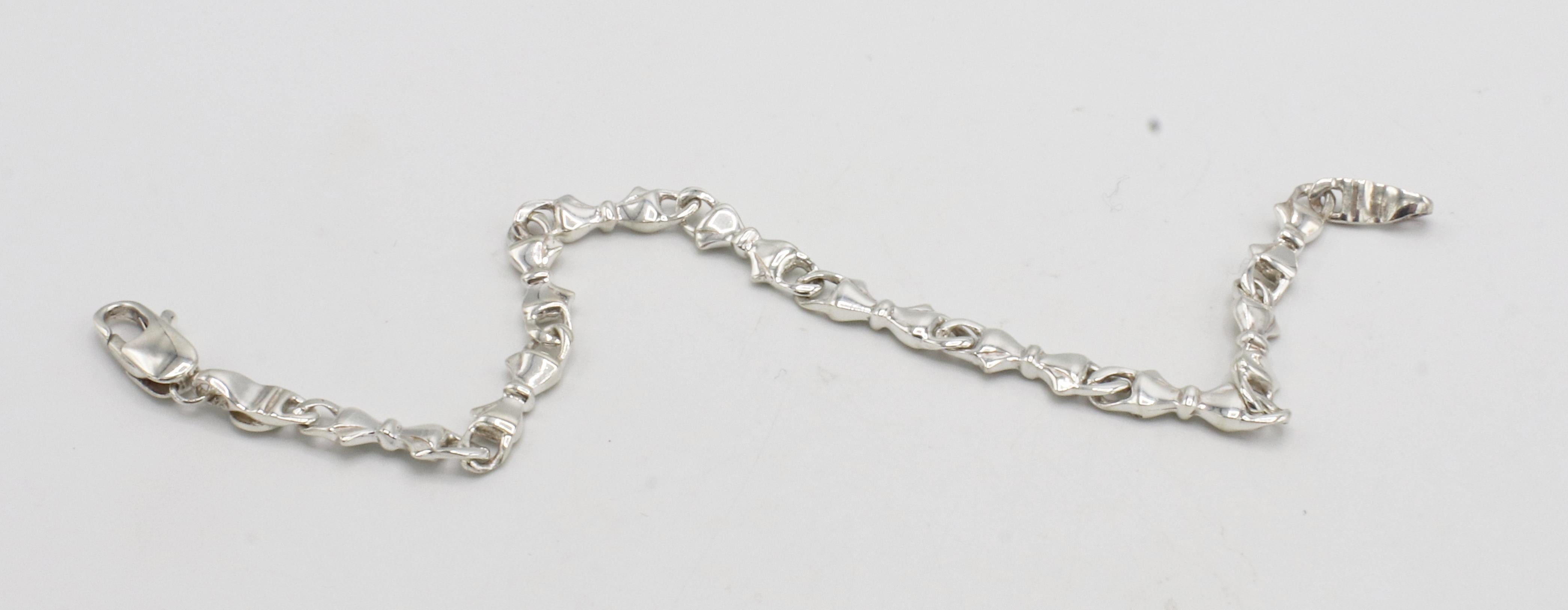 Tiffany & Co. Bracelet à maillons en argent sterling avec nœud 
Métal : Argent sterling
Poids : 9,68 grammes
Longueur : 7,5 pouces
Largeur : 5mm
Signé : T&Co. 925
