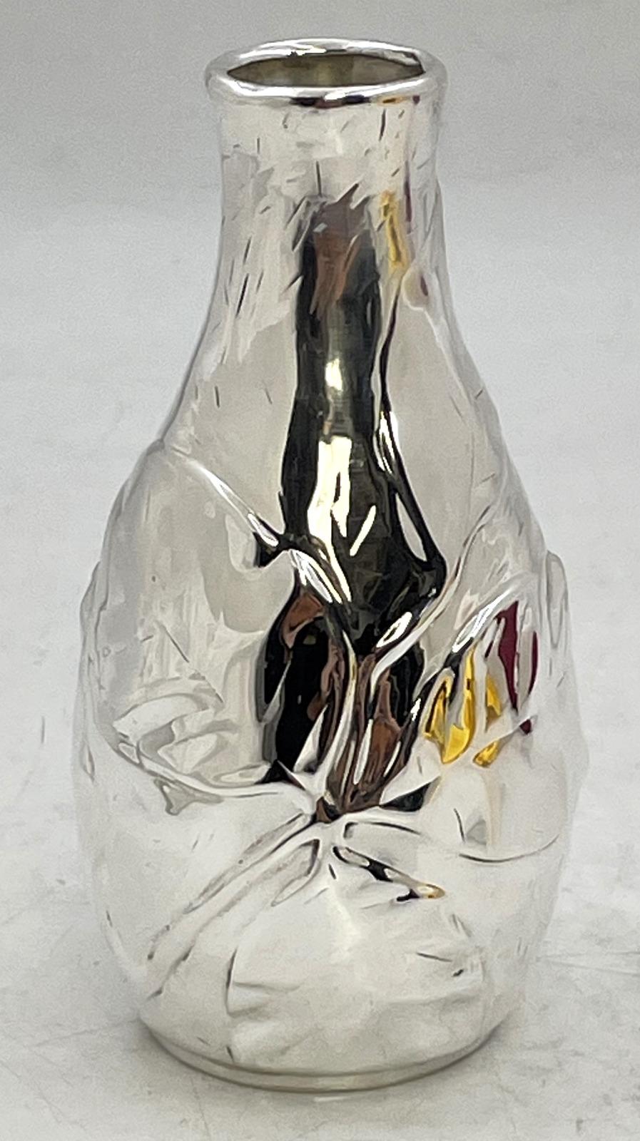 Vaso a bocciolo in argento sterling di Tiffany & Co. disegnato da Louis Comfort Tiffany, ornato con motivi naturali. Misura 5 1/3'' di altezza per 1 1/8'' di diametro nella parte superiore, pesa 5,2 once troy e reca i marchi come mostrato. 

Il