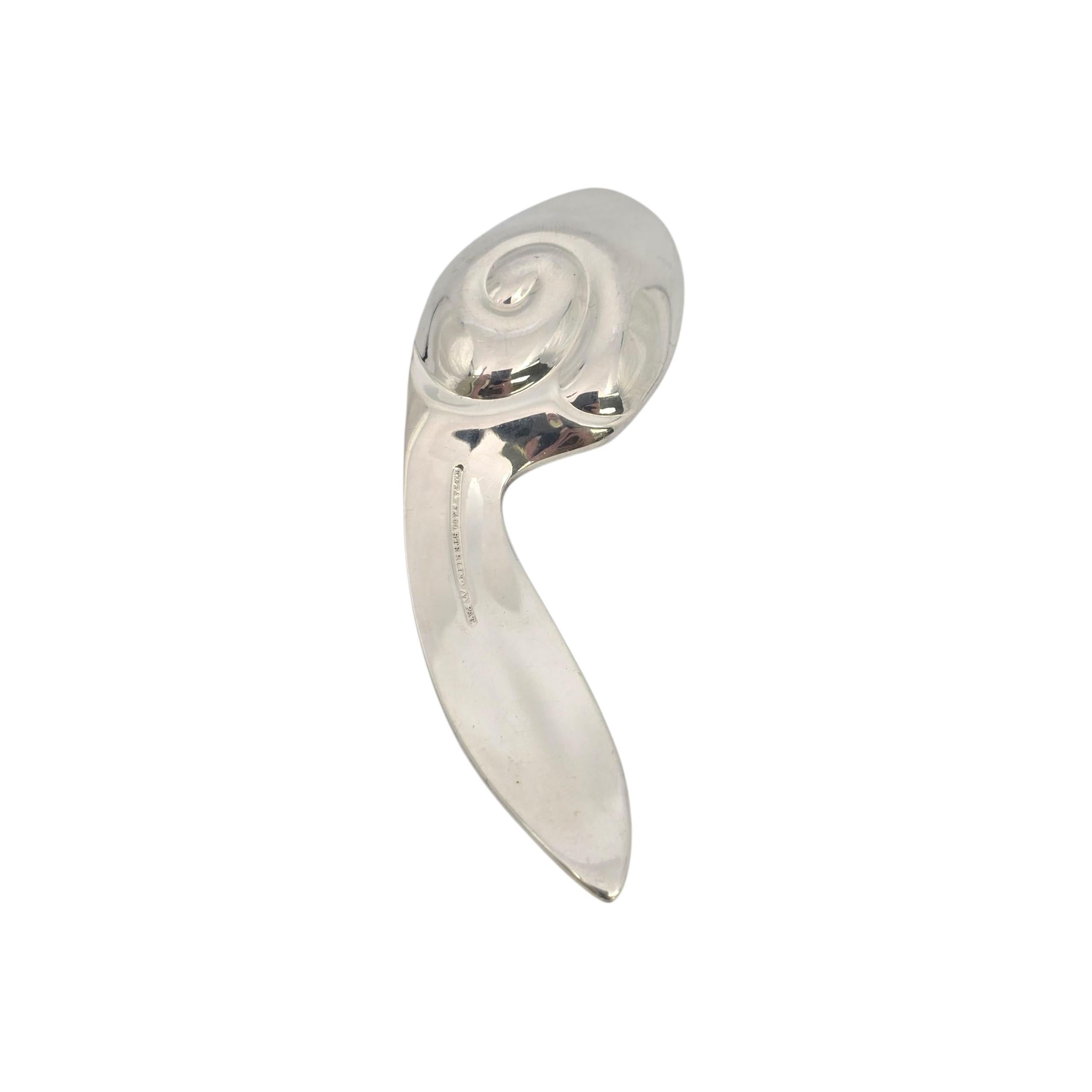 Tiffany & Co sterling silver bunny rabbit ear baby spoon.

No monogram or engraving

A small curved baby spoon featuring a bunny ear design handle and a swirl accent on the handle. The M hallmark dates this piece to manufacture under the