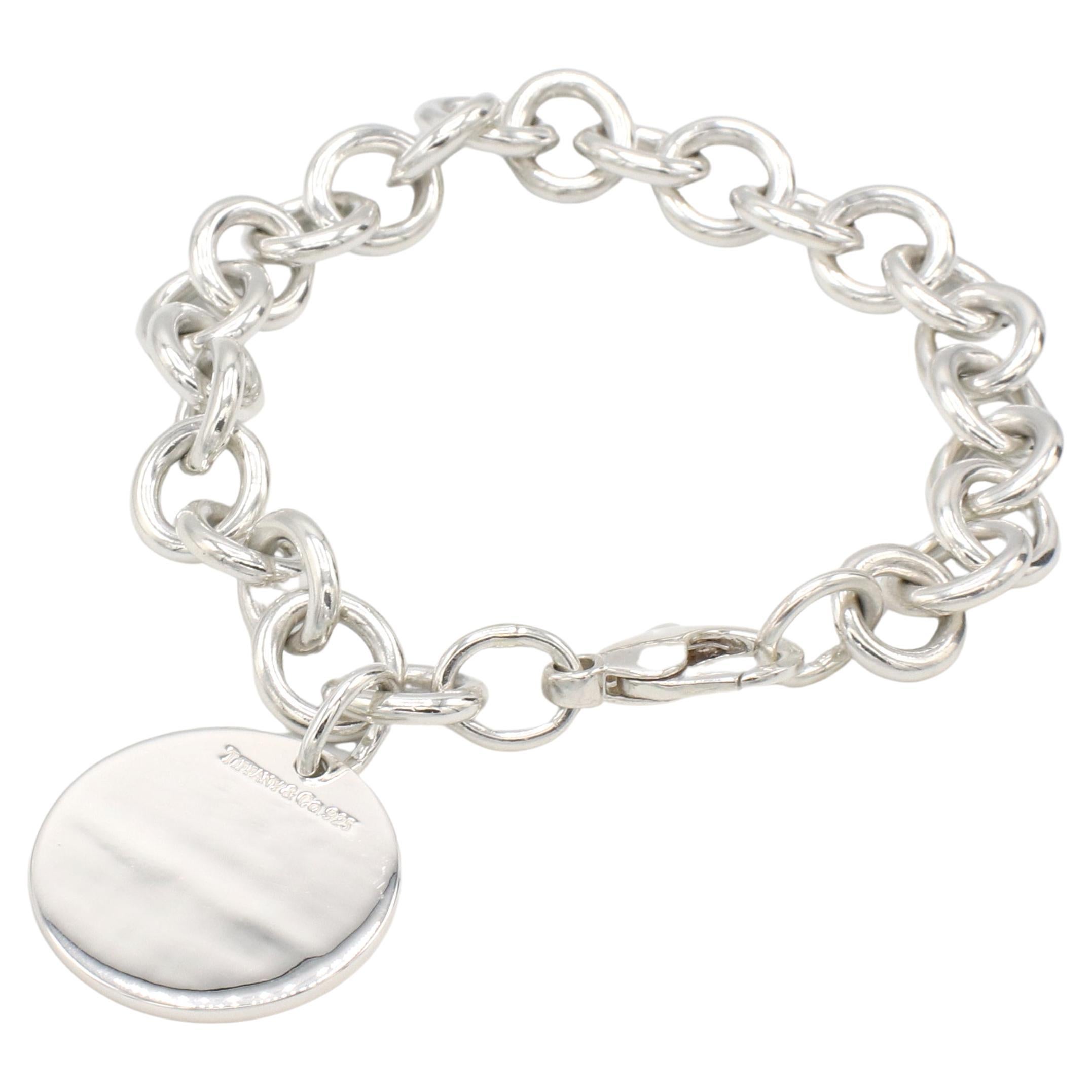 Tiffany & Co. Sterling Silver Chain Link Circle Charm Disc Bracelet 
Metal: Sterling silver
Weight: 35.8 grams
Length: 7.5 inches
Links: 10 x 11mm
Charm: 23.5mm
Signed: Tiffany & Co. 925
