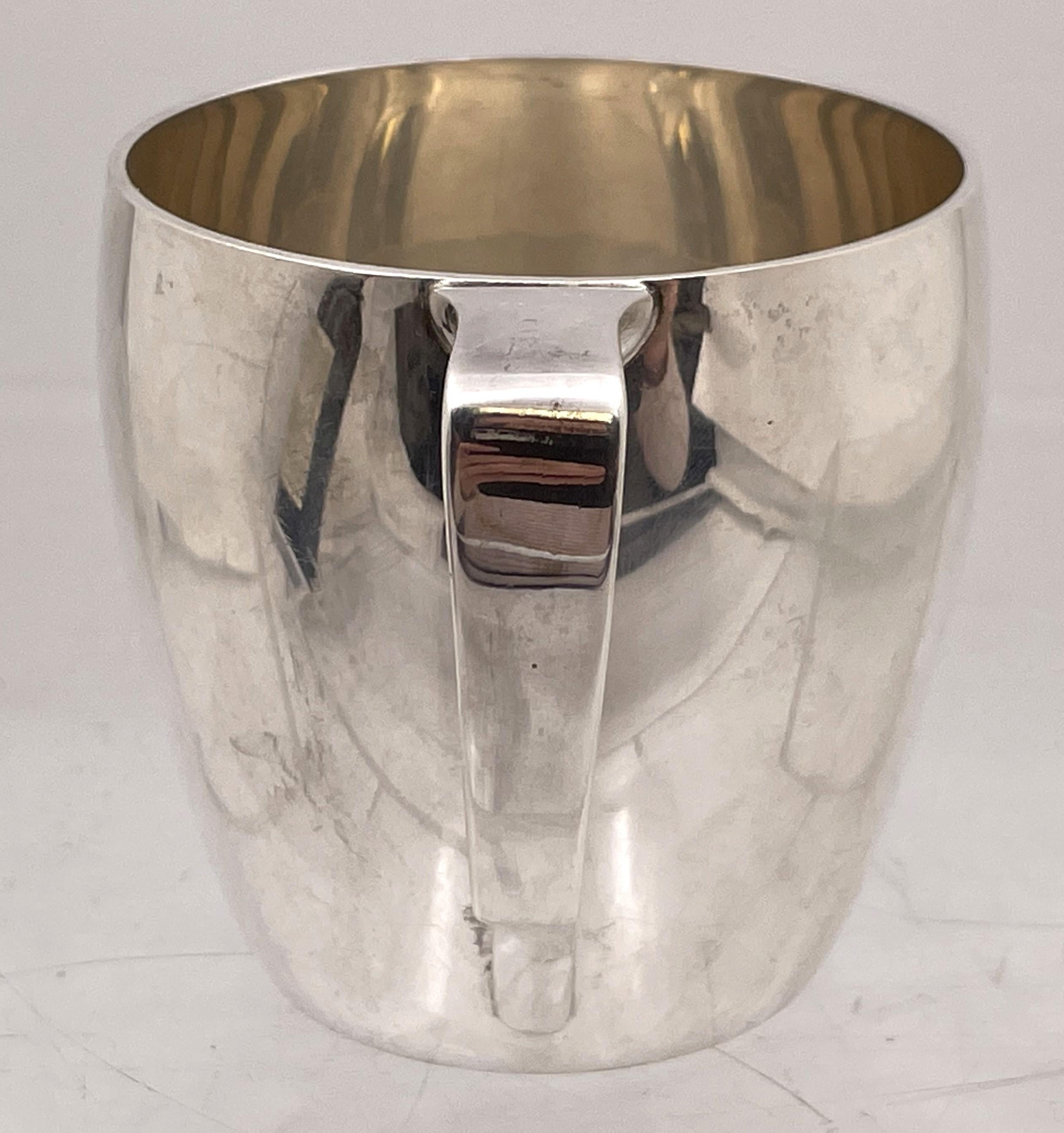 Tiffany & Co. sterling silver child Christening mug in Mid-Century Modern style, with an elegant geometric design. It measures 2 3/4'' in height by 2 3/4'' in diameter at the top, and bears hallmarks as shown. 

The legendary Tiffany brand was