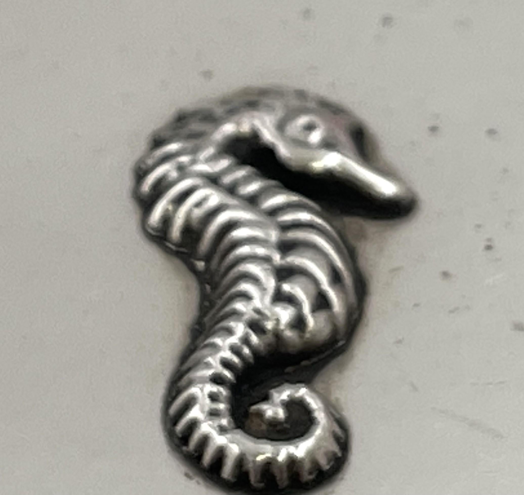 Portacipria in argento sterling di Tiffany & Co. con un motivo a cavalluccio marino che adorna la parte superiore, risalente agli inizi del XX secolo. Una volta aperto, c'è uno specchio e un coperchio per il trucco (attualmente in polvere) come