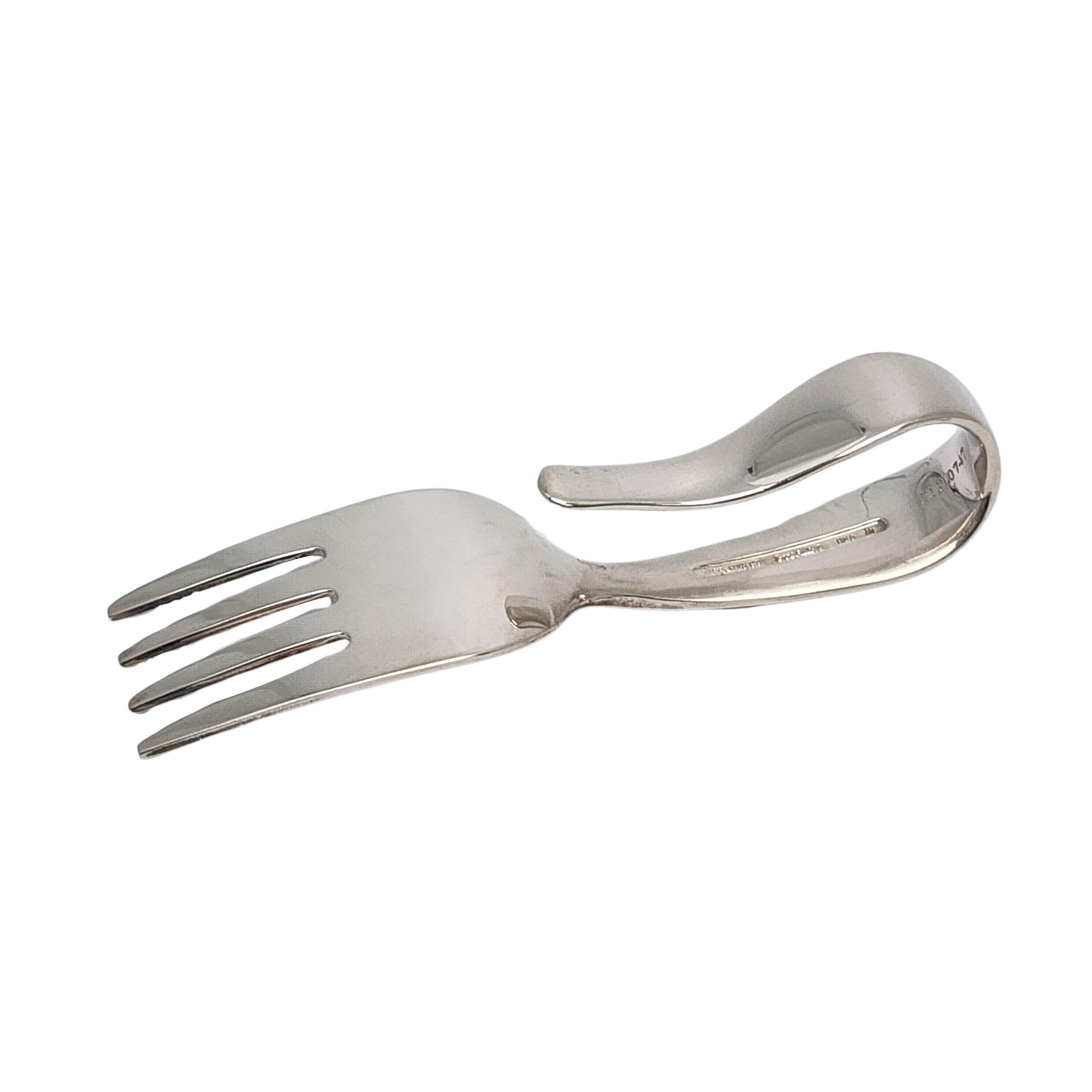 Sterling silver baby fork with curved loop handle by Tiffany & Co.

Timeless small baby/child feeding fork featuring a curved loop handle. Hallmarks date this piece to manufacture under the directorship of John C. Moore II, 1907-1947.  Does not