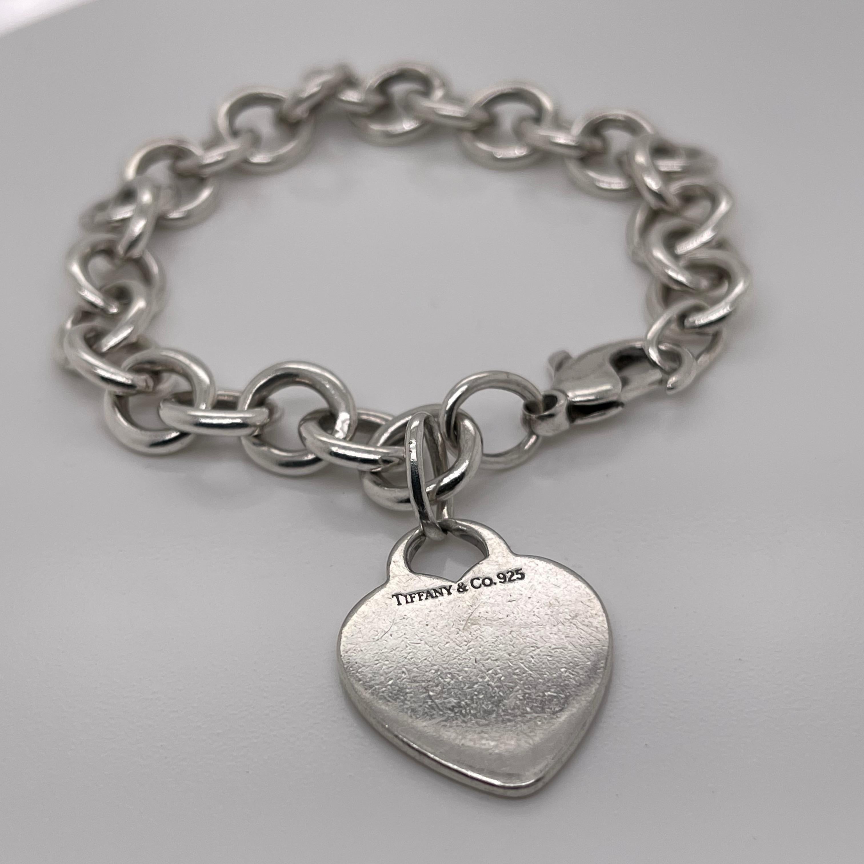 A fine Tiffany & Co. sterling silver bracelet.

With slightly oval links and a heart-shaped pendant charm.

The charm is not engraved.

Great Tiffany design!

Date:
20th Century

Overall Condition:
It is in overall good, as-pictured, used estate