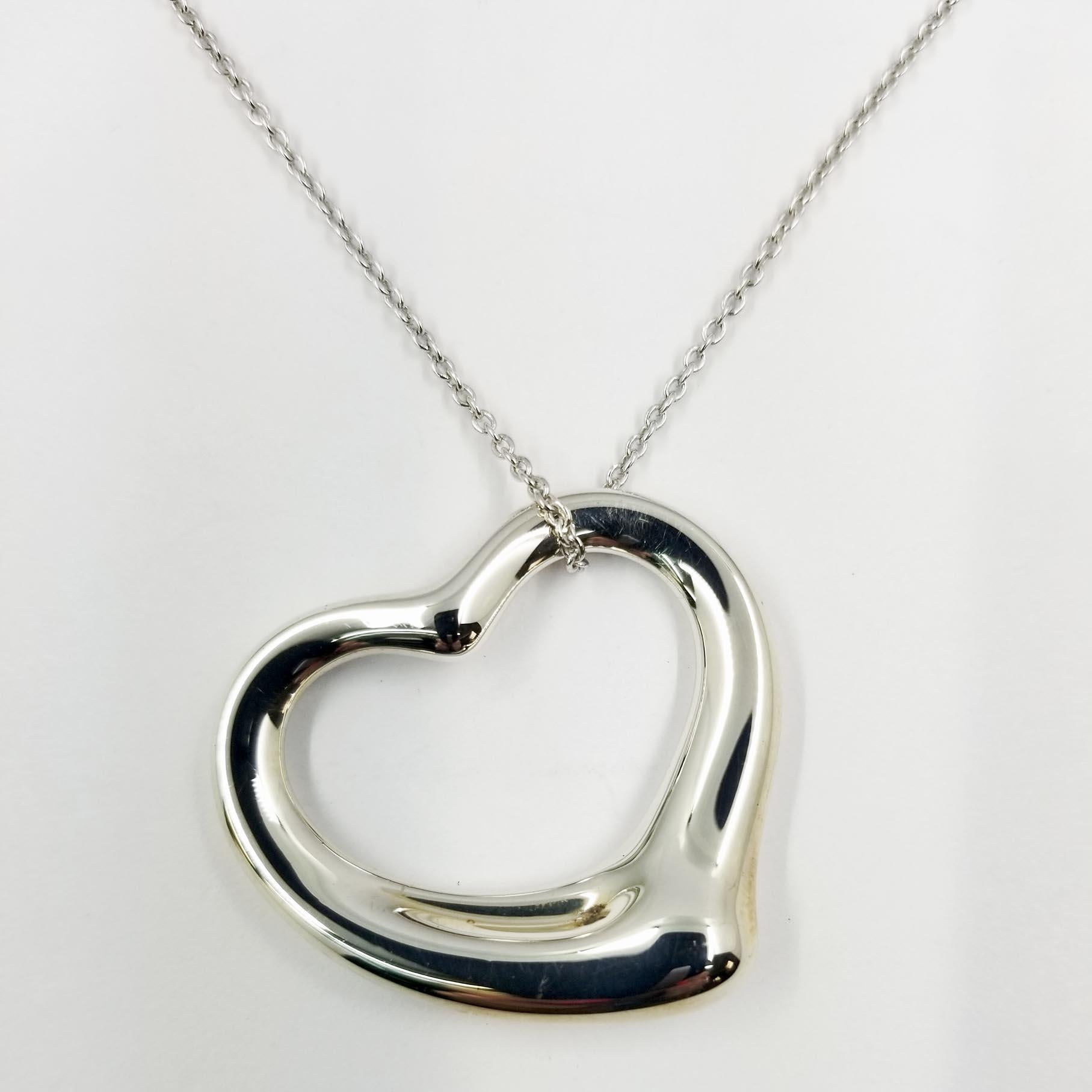 This playful sterling silver heart pendant was designed for Tiffany & Co by Elsa Peretti. The back of the curved heart is engraved Tiffany & Co. with Elsa Peretti's signature, 925, and Spain. The signed pendant is on a non-branded 16 inch sterling