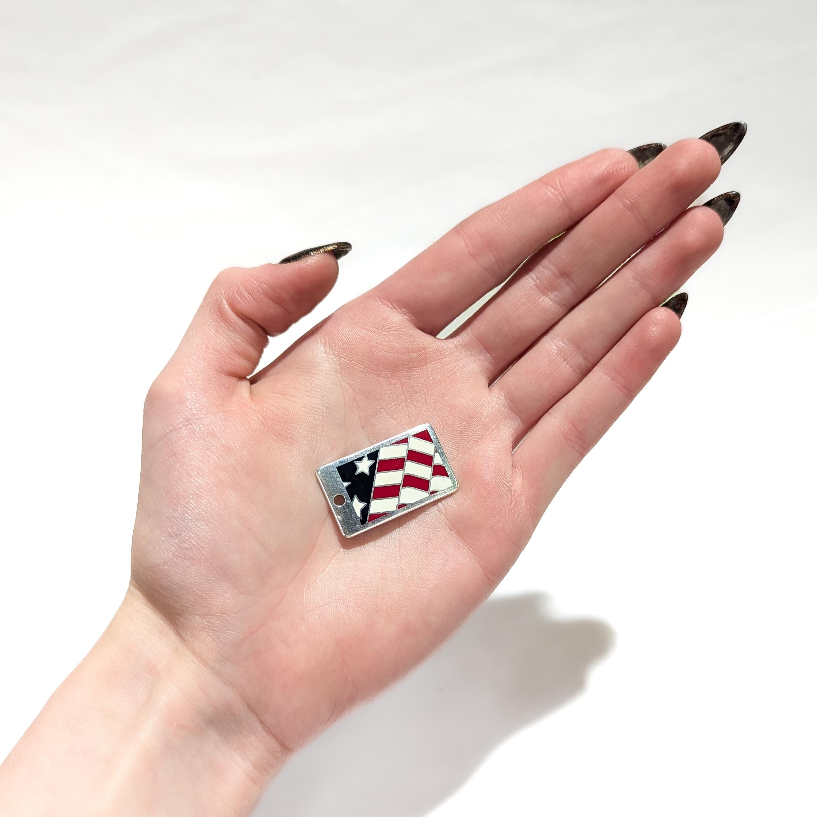Eine feine Silber & Emaille Charme Anhänger oder Hundemarke.

Von Tiffany & Co.

Aus Sterlingsilber.

Mit einer emaillierten amerikanischen Flagge in Rot, Weiß und Blau auf der Vorderseite.

Dieser Anhänger war wahrscheinlich ursprünglich Teil eines