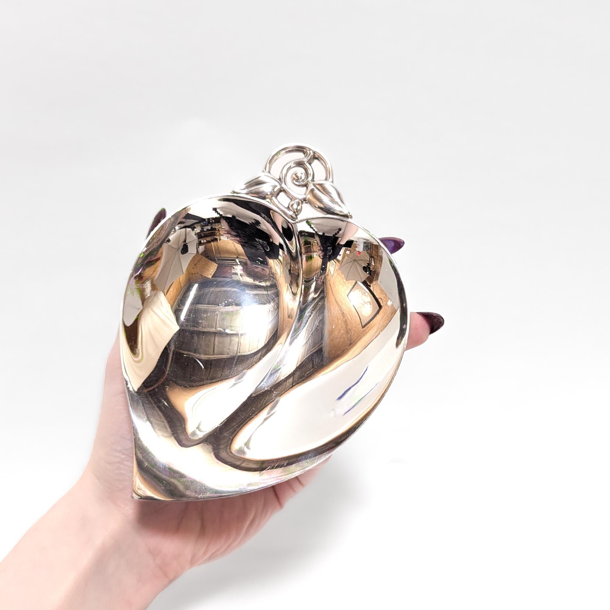 Un bel piatto o vide poche d'argento firmato.

Da Tiffany & Co.

In argento sterling. 

Modello n. 22885.

A forma di foglia a cuore con gambo figurato e manico traforato a foglia e due piedi a sfera.

Marcato alla base.

Un design Tiffany