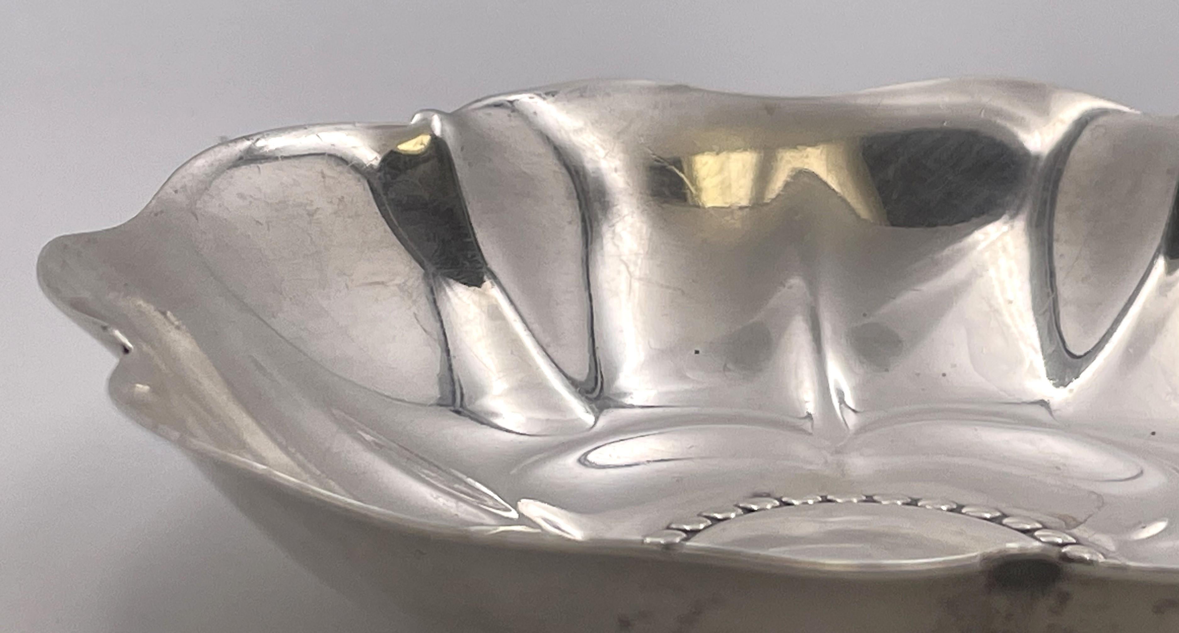 Tiffany & Co. sterling silver nut dish or bowl in pattern number 22954 from 1941 with a floral, multilobed design. It measures 5'' in diameter by 1 1/8'' in height, weighs 4.8 troy ounces, and bears hallmarks as shown.

The legendary Tiffany brand