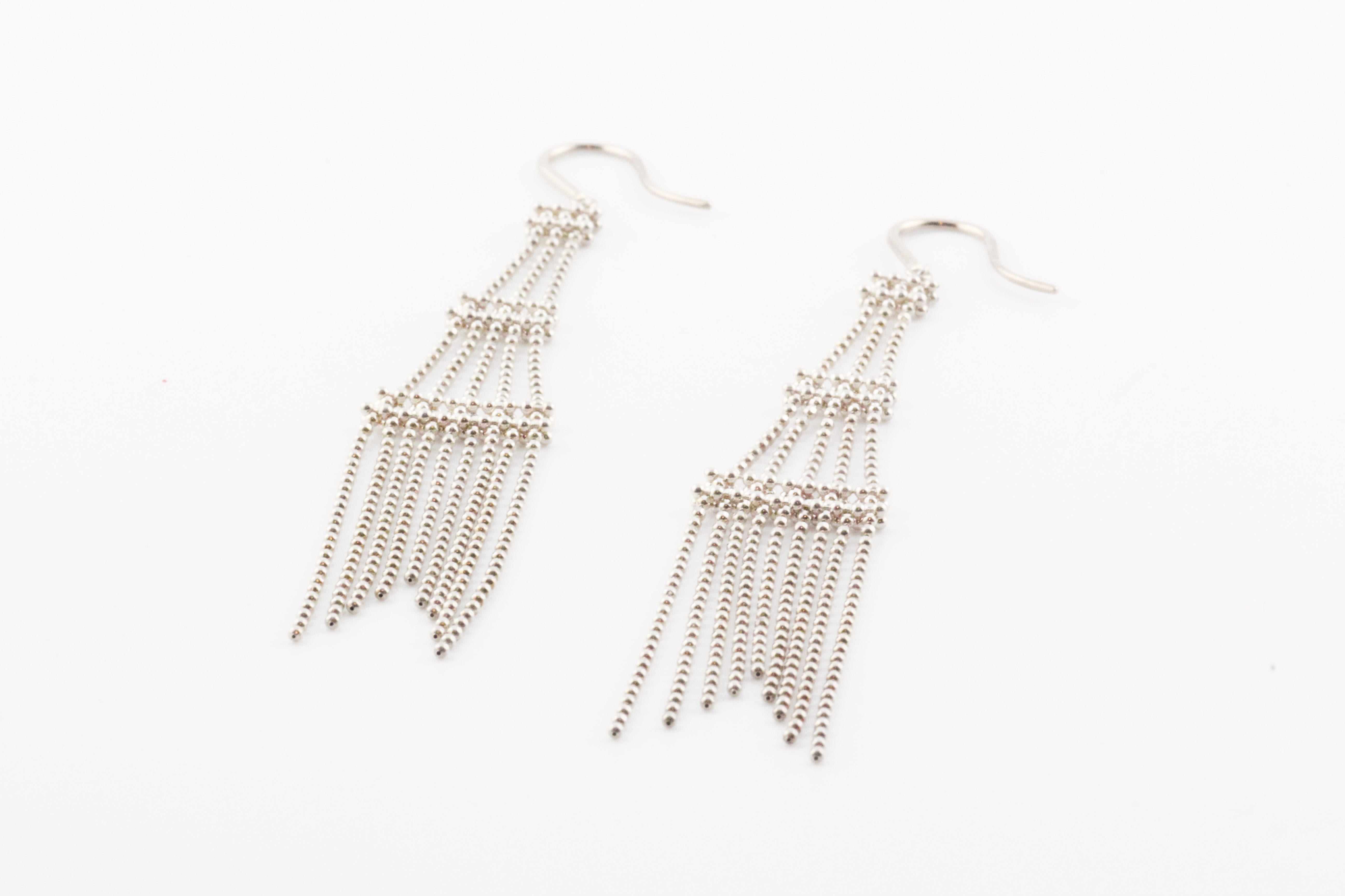 The Tiffany & Co. Sterling Silver Fringe Bead Tassel Drop Dangle Tower Earrings are a dazzling expression of sophistication and contemporary elegance. Crafted by the renowned jewelry house Tiffany & Co., these earrings are a testament to the brand's