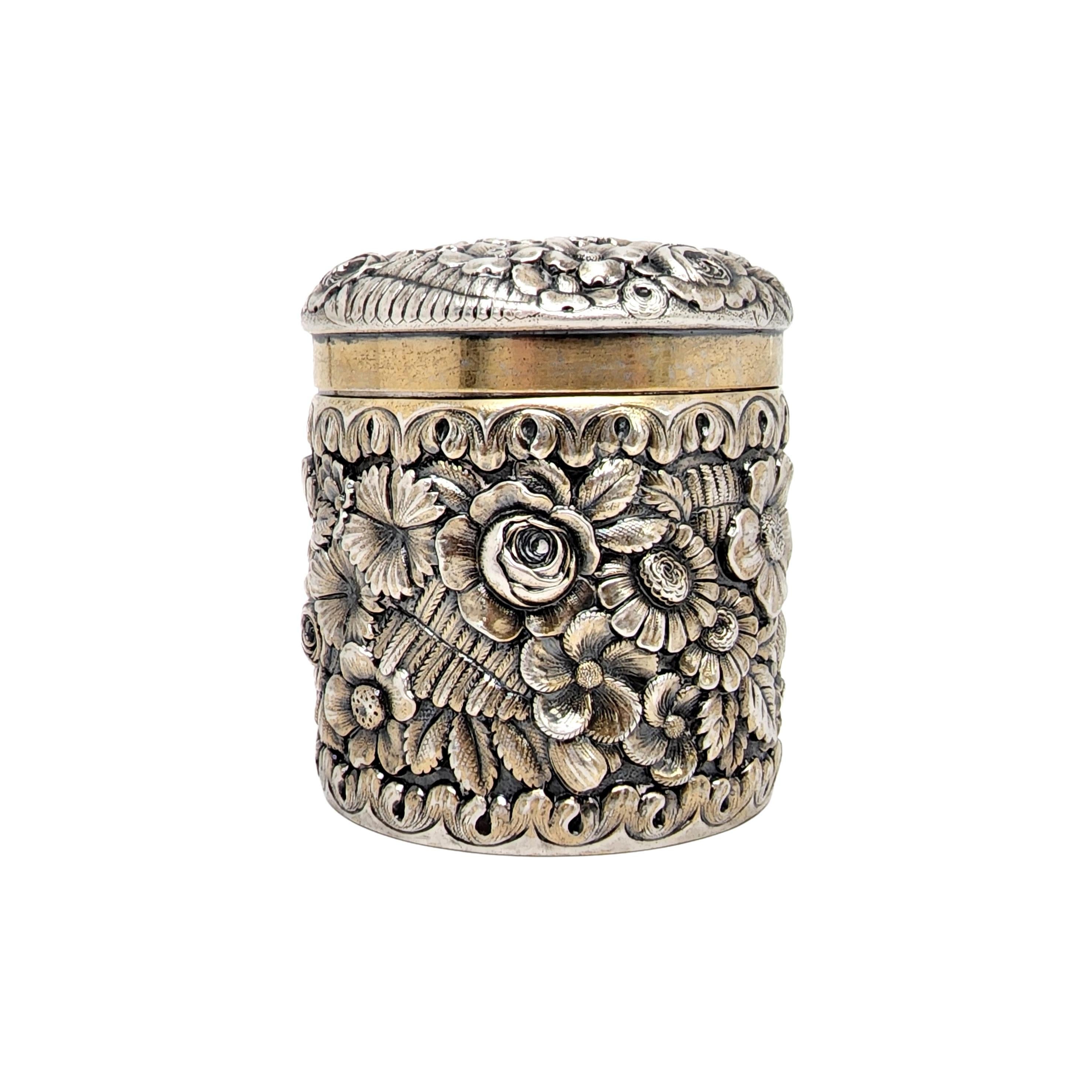 Tiffany & Co sterling silver gold wash repousse floral & fern canister box.

A beautifully ornate repousse flower and fern leaf design with gold wash accents and gold wash interior. Hallmarks date this piece to manufactured under the directorship of