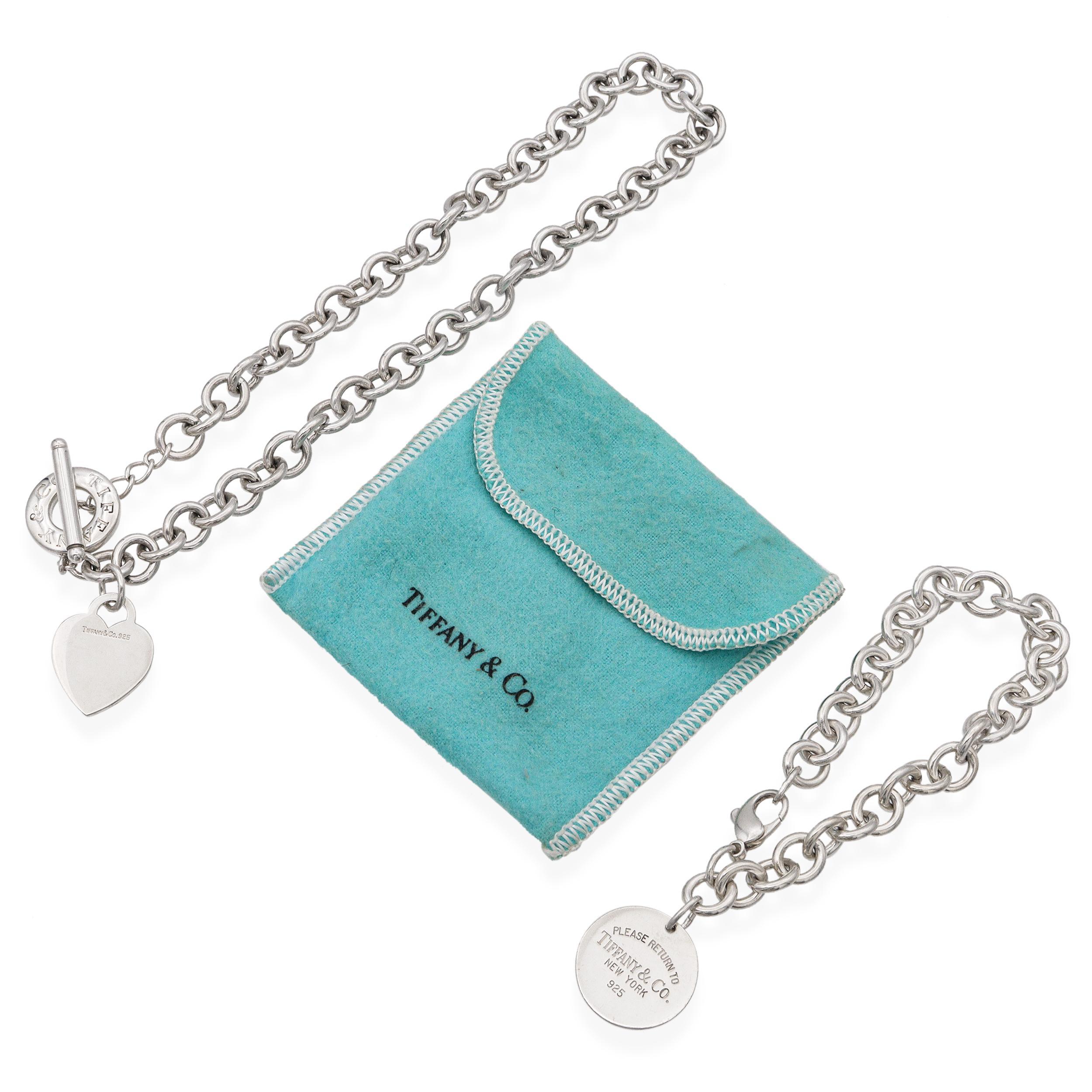 This iconic Tiffany & Co. set includes a classic heart tag toggle necklace and a matching round tag charm bracelet, both crafted from luxurious sterling silver. The necklace features the signature heart-shaped charm with toggle closure, while the