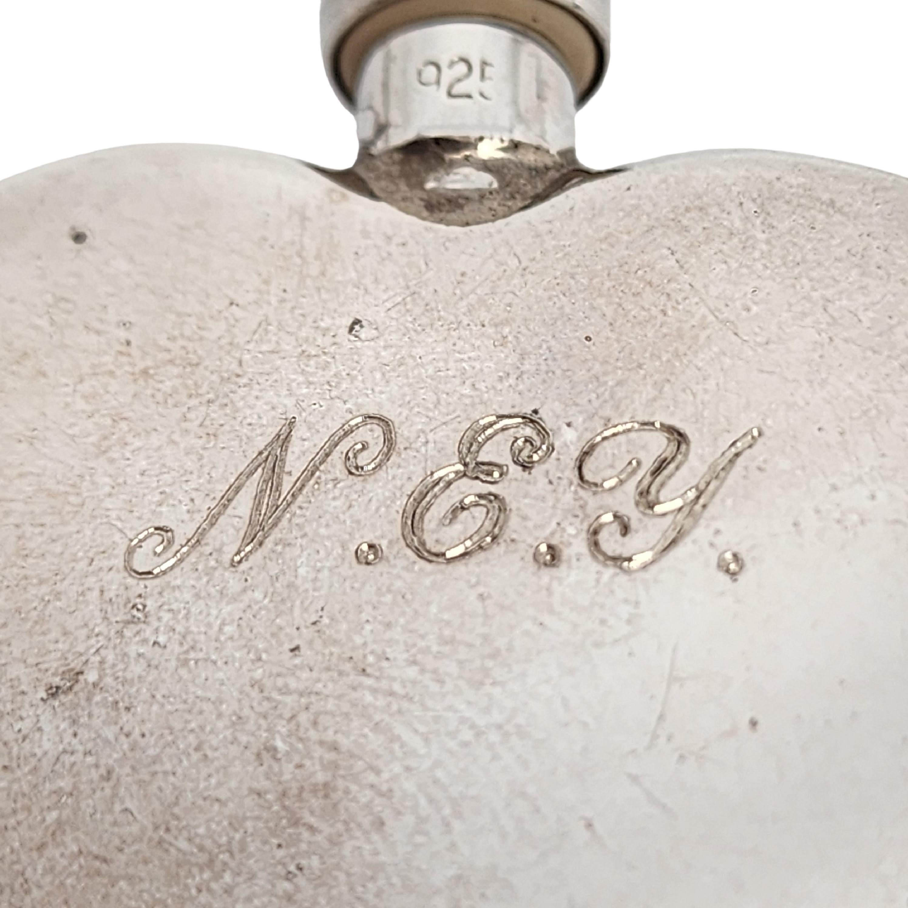 Vintage sterling silver heart perfume bottle by Tiffany & Co with monogram.

Monogram appears to be NEY

This beautiful scent bottle features a heart shaped bottle with smooth polished design on both sides and a screw-off top with dauber attached.