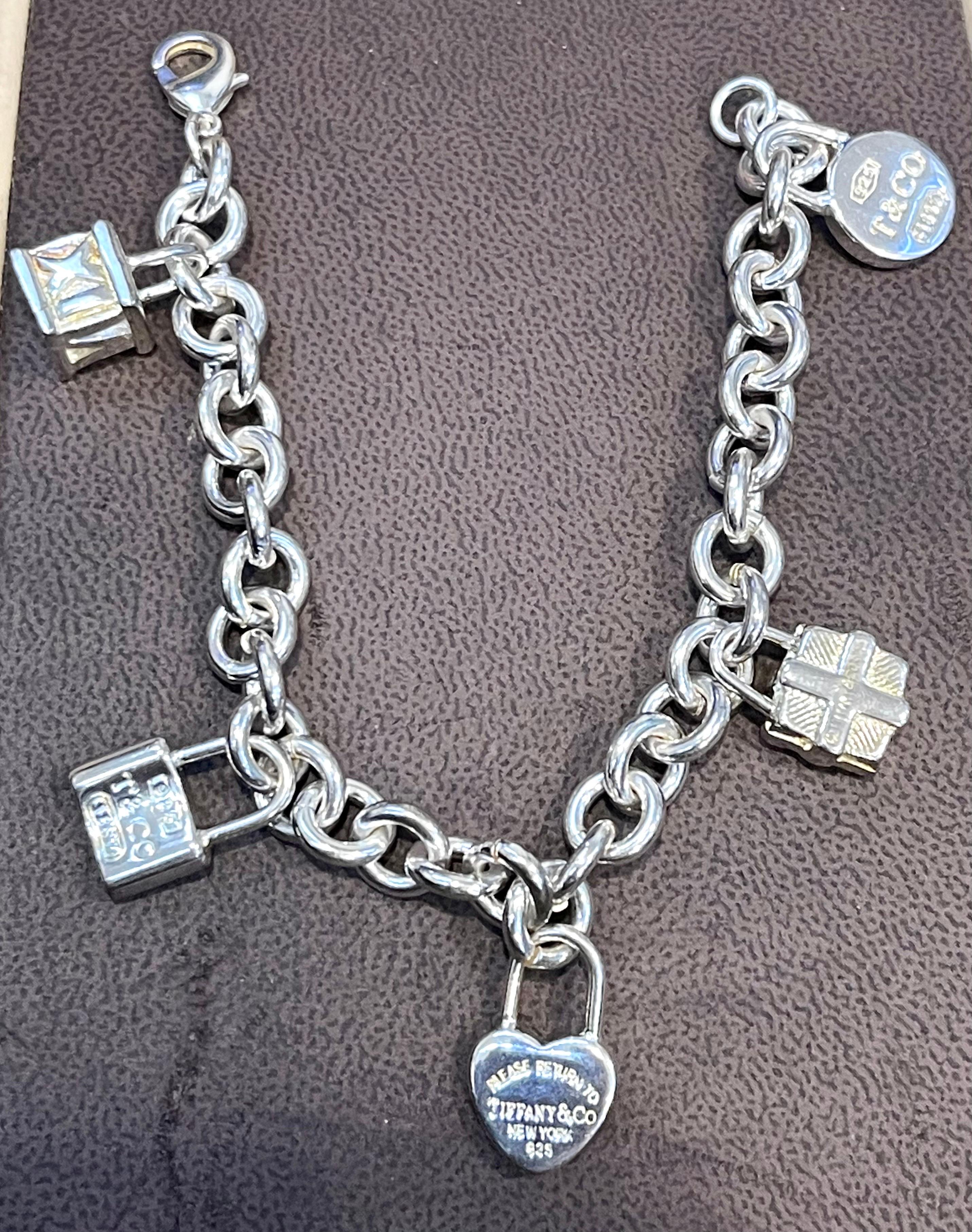 Tiffany & Co. Sterling Silver Heart Tag Lock & Bag Charm Bracelet Tiffany & Co. Box, 42 Grams
An elite authentic bracelet from Tiffany & Co., forged from silver with a fine polished finish, it features a sturdy oval chain link bracelet with 5 solid 