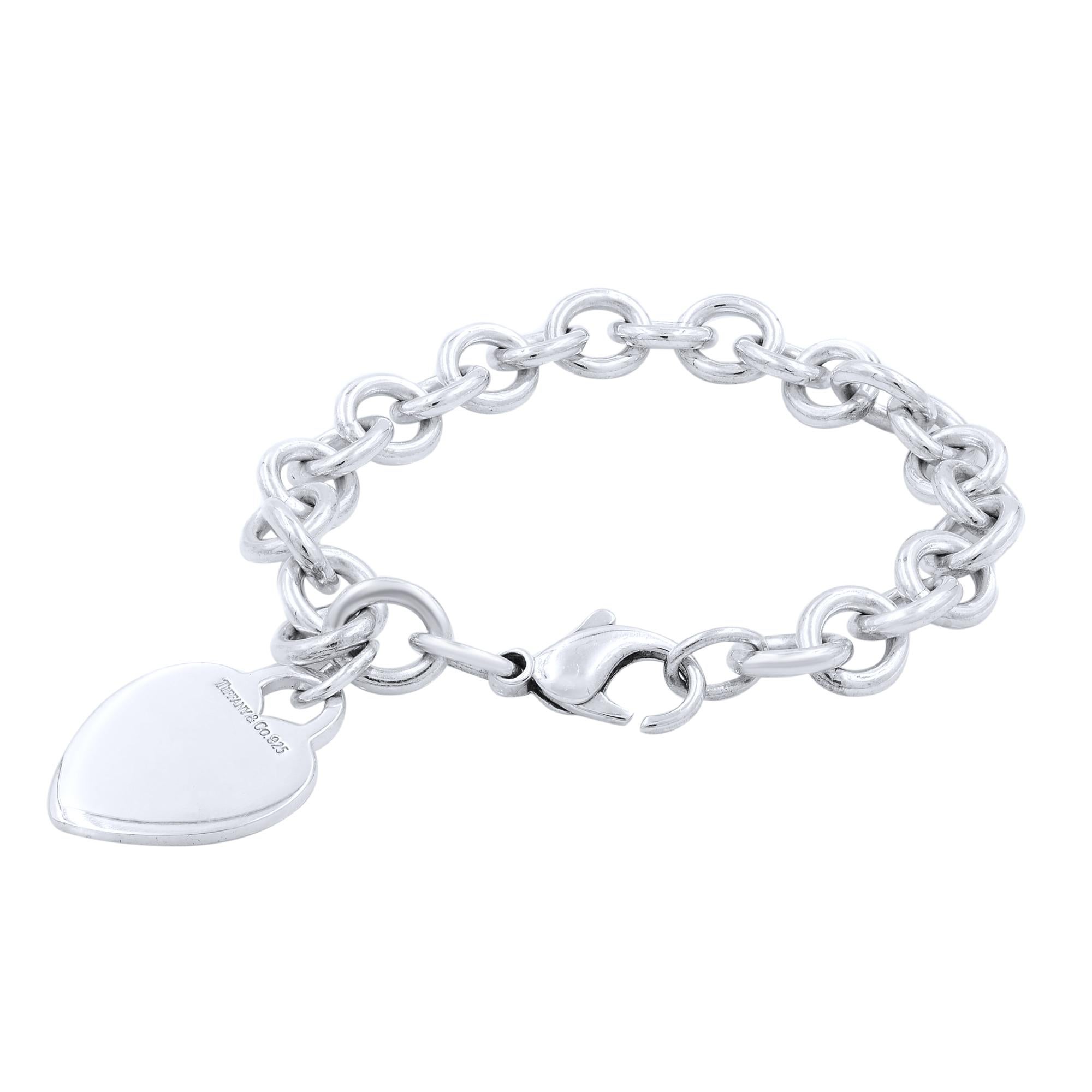 An elite authentic bracelet from Tiffany & Co., forged from silver with a fine polished finish, it features a sturdy oval chain link bracelet with a solid heart tag charm. The bracelet has a large lobster clasp and it has full designer signature