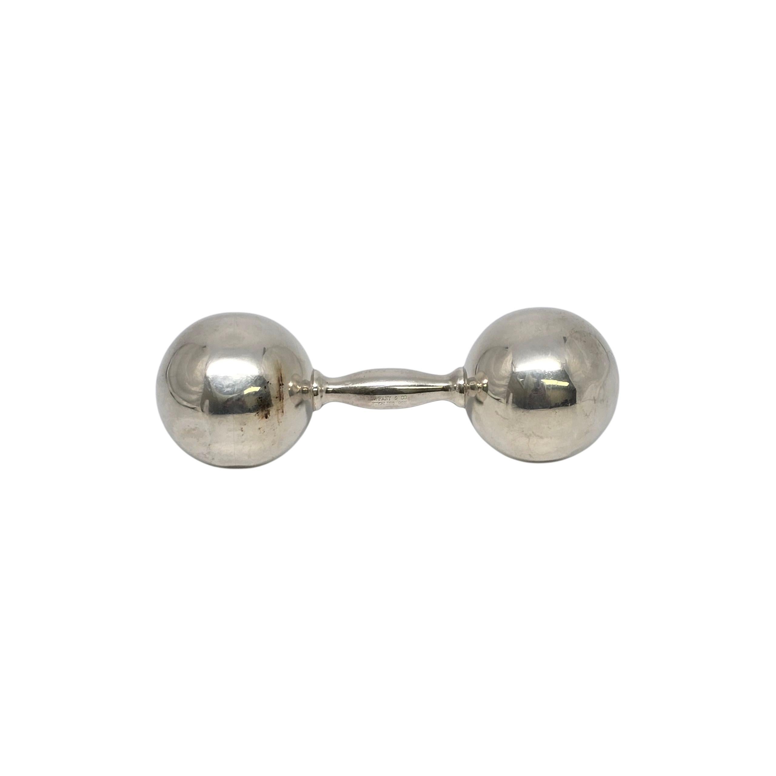 Tiffany & Co large sterling silver barbell rattle with monogram.

Monogram appears to be TCB

This is a beautiful and charming authentic larger sized sterling silver dumbbell baby rattle designed by Tiffany & Co. It has a soft sweet jingle when you