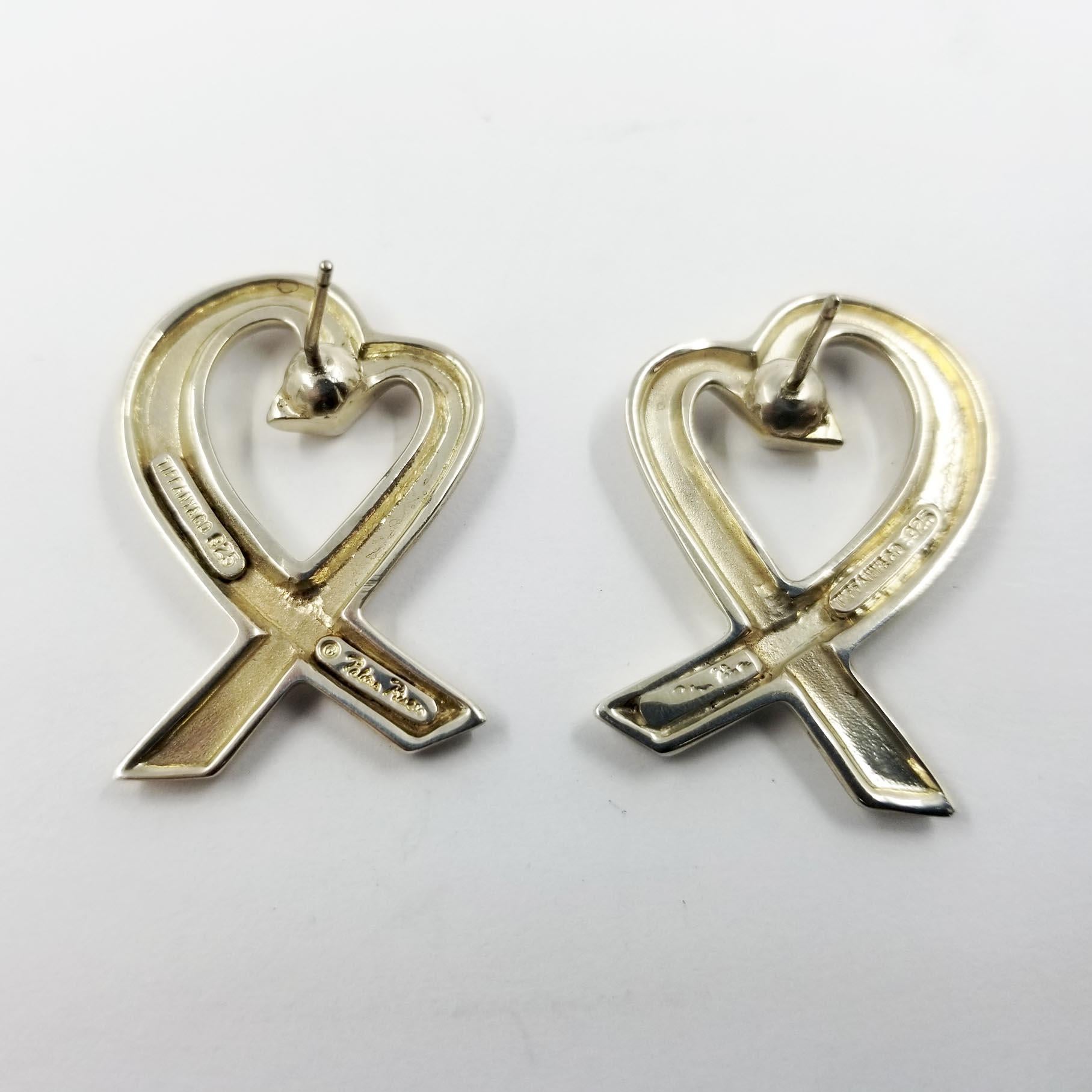 These large stud earrings are designed by Paloma Picasso for Tiffany & Co. The hearts are crafted in sterling silver. The backs are engraved with Paloma Picasso's signature, Tiffany & Co, and 925. Post with friction nut. Professionally polished to