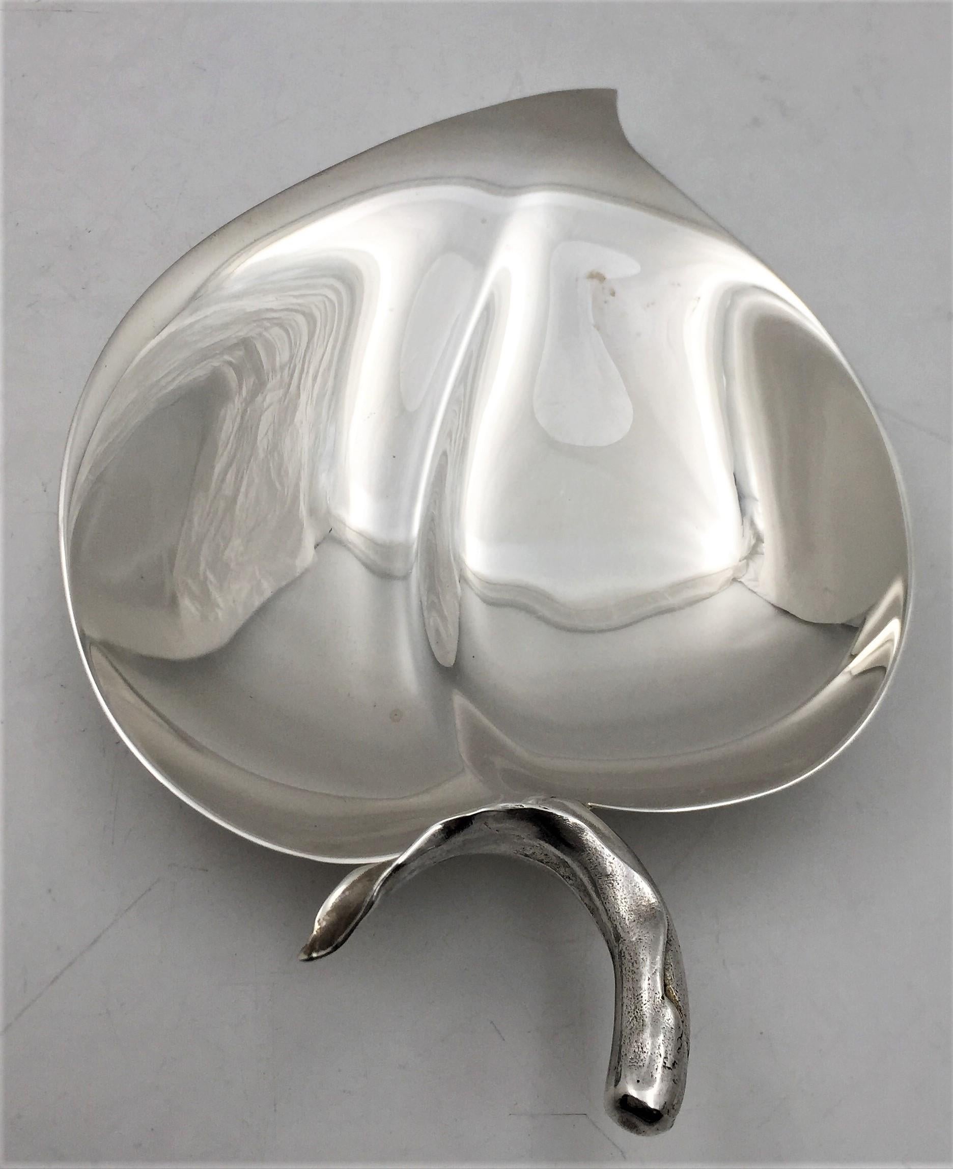 Tiffany & Co. sterling silver dish in pattern number 25053 from the 1950s and in Mid-Century Modern style with a beautiful geometric design. The dish stands on 2 balled feet and has a highly realistic handle. It measures 6 1/2'' in length by 4 1/4''