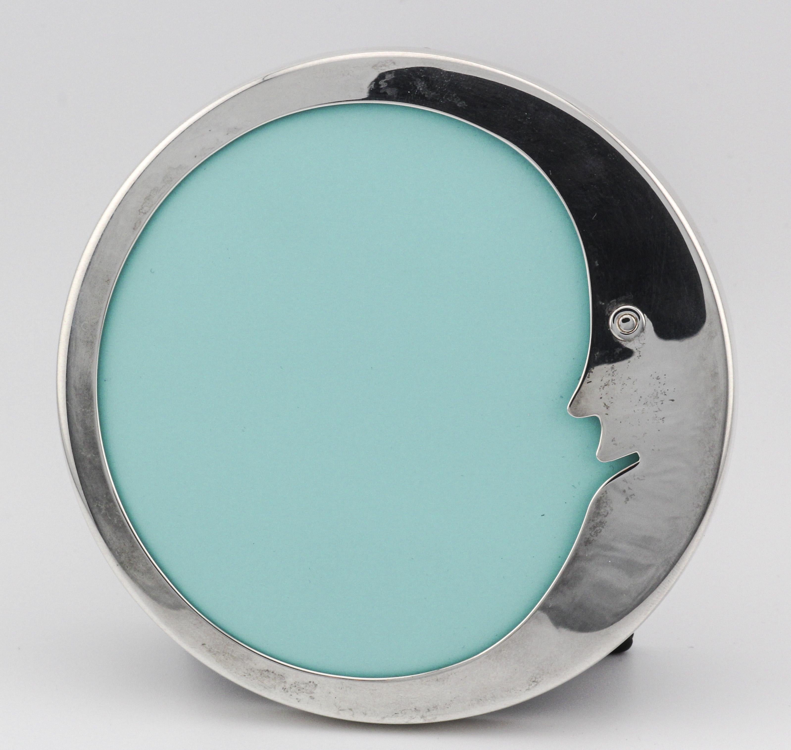 The Tiffany & Co. Sterling Silver Leather Crescent Moon Round Picture Frame is a beautifully crafted piece that exudes both elegance and whimsy. The frame is skillfully made from radiant sterling silver, with a smooth, polished surface that catches