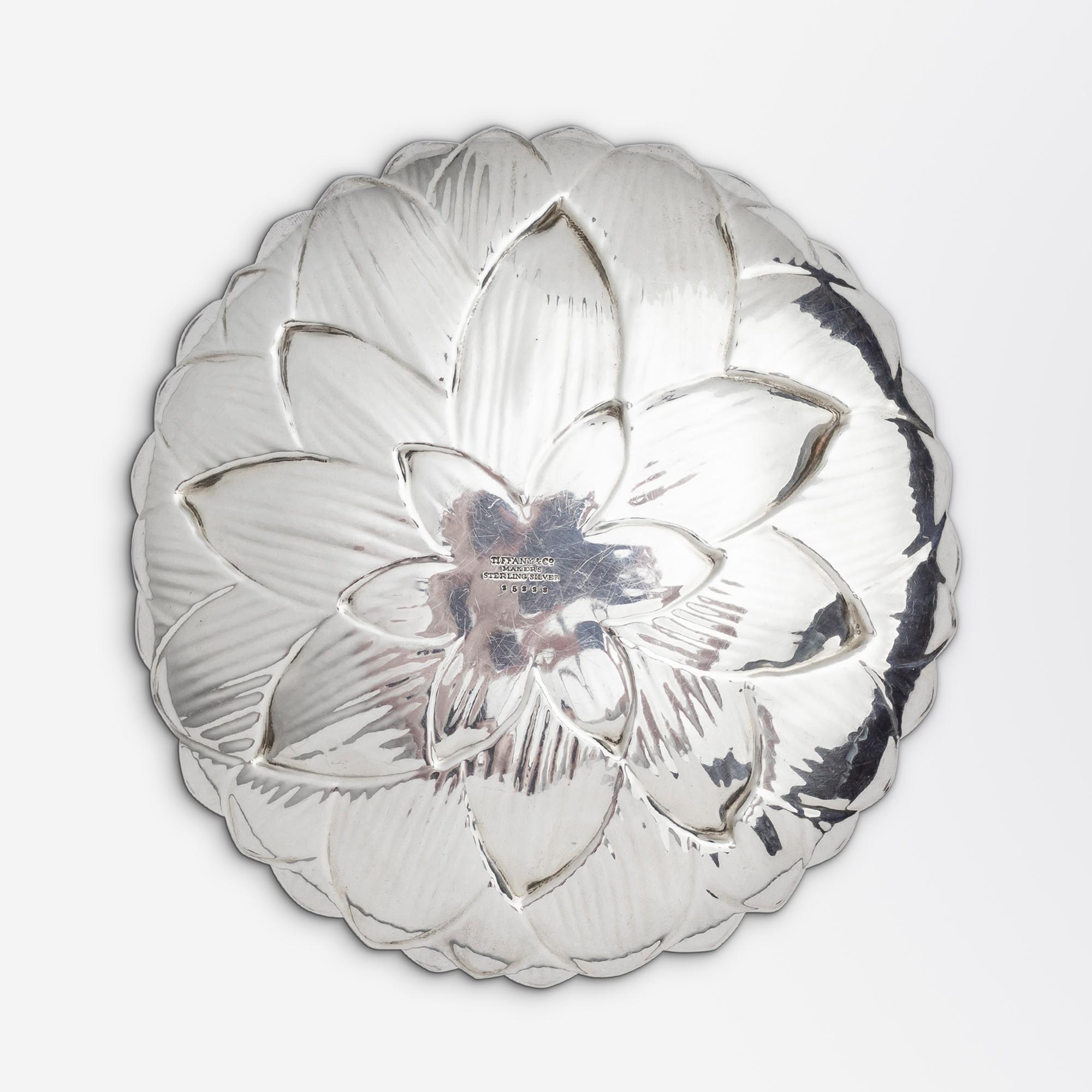A sterling silver dish in the form of a lotus blossom or water lily by esteemed maker, Tiffany & Co. The round dish features a post 1965 hallmark for manufacture by the firm and has a pattern number of '25223'. The dish is sculpted to curl up