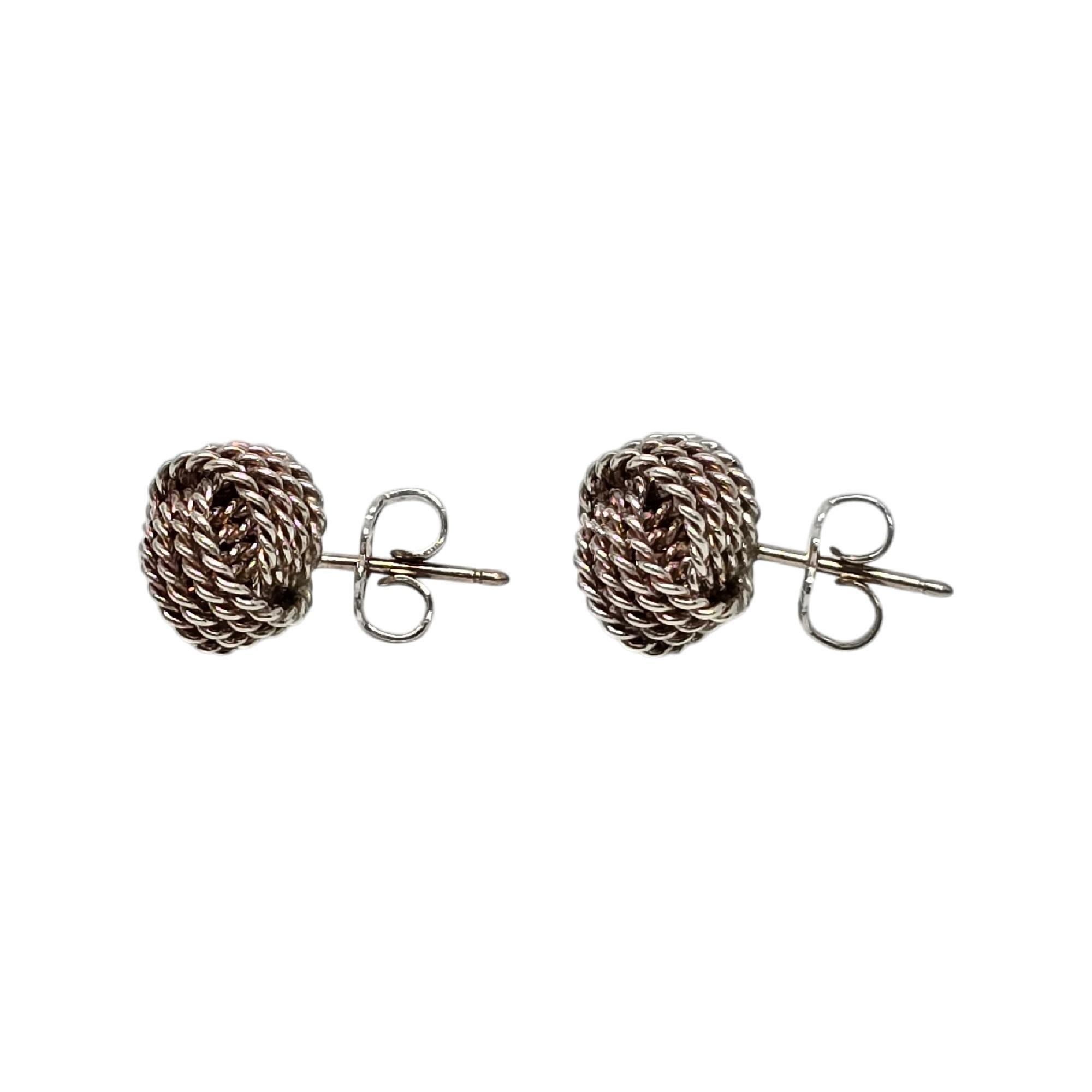 Boucles d'oreilles en argent sterling avec nœud en maille de Tiffany & Co.

Boucles d'oreilles authentiques de Tiffany présentant un motif de nœuds. La boîte et la pochette Tiffany & Co ne sont pas incluses.

Mesure environ 9 mm de diamètre.

Pèse
