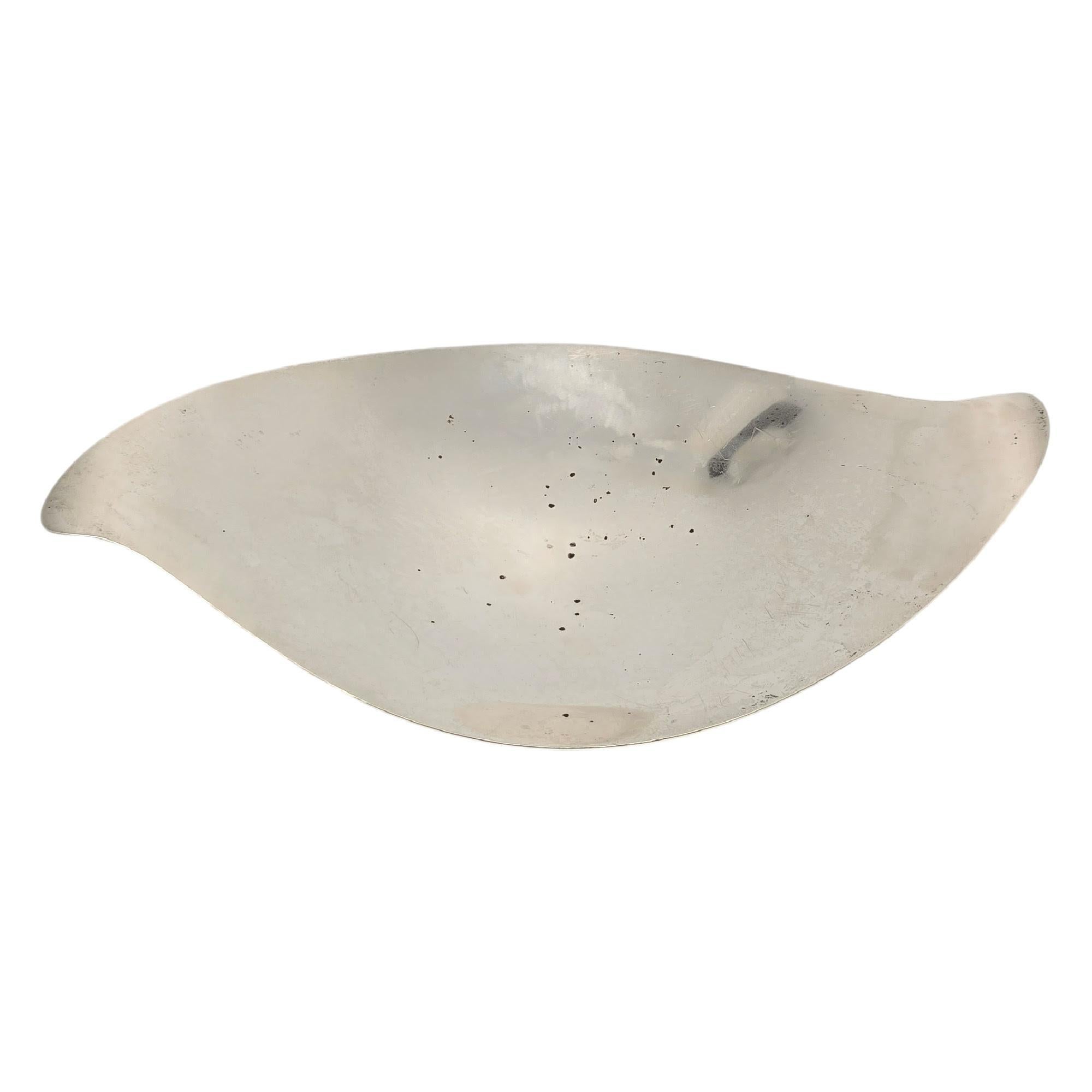 Sterling silver Mid-Century leaf bowl by Tiffany & Co, pattern # 23346.

A large, long leaf shaped bowl featuring downturned ends and 4 ball feet on the bottom. Hallmarks date these pieces to manufacture under the directorship of Louis deBebian