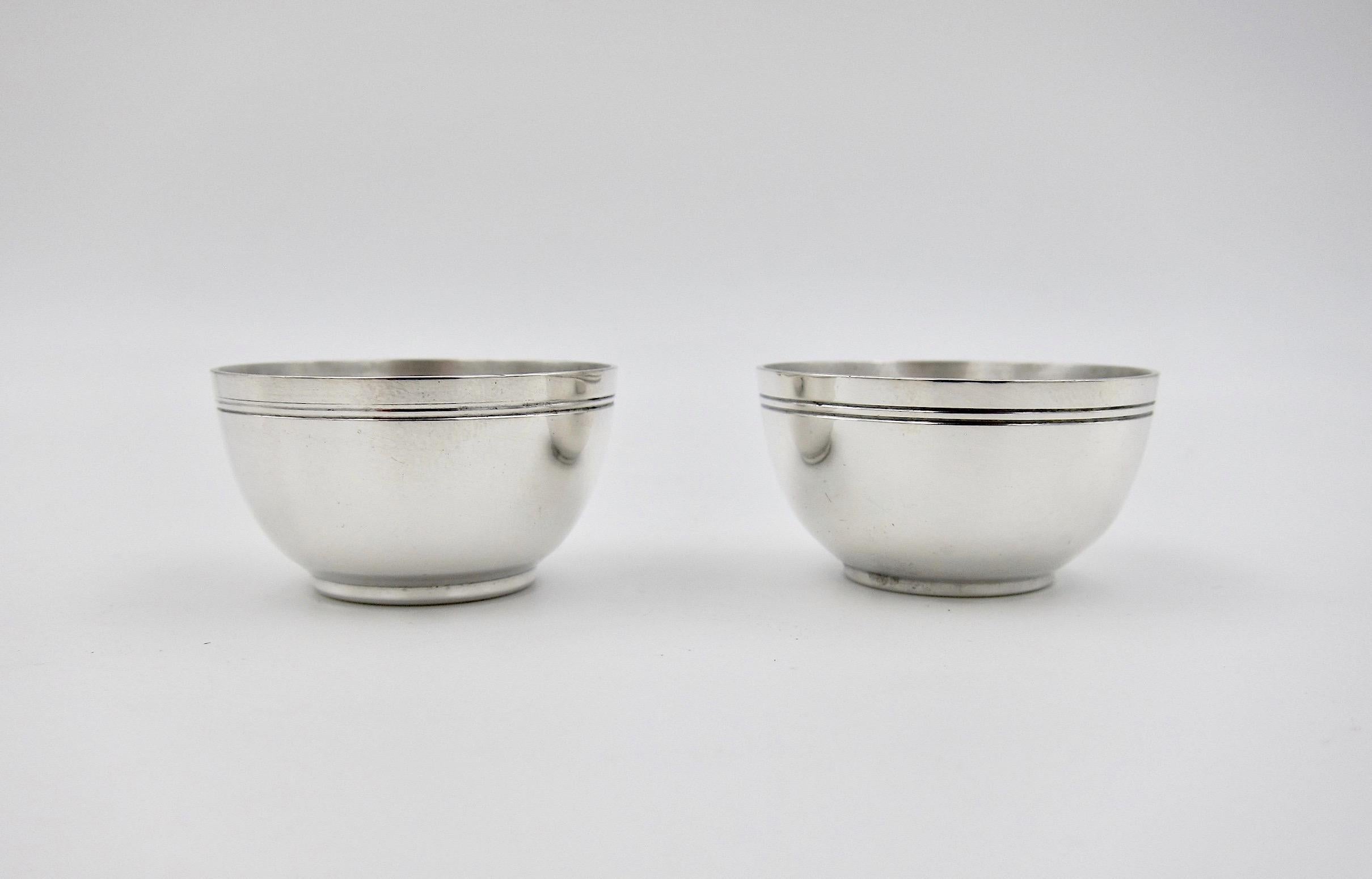 A Tiffany & Co. pair of sterling silver miniature bowls or open salt cellars. The hollowware pattern number is 20336 which date the pieces to 1924.

Very good condition, measuring .75 in. H x 1.5 in. diameter and stamped Tiffany & Co / Makers /