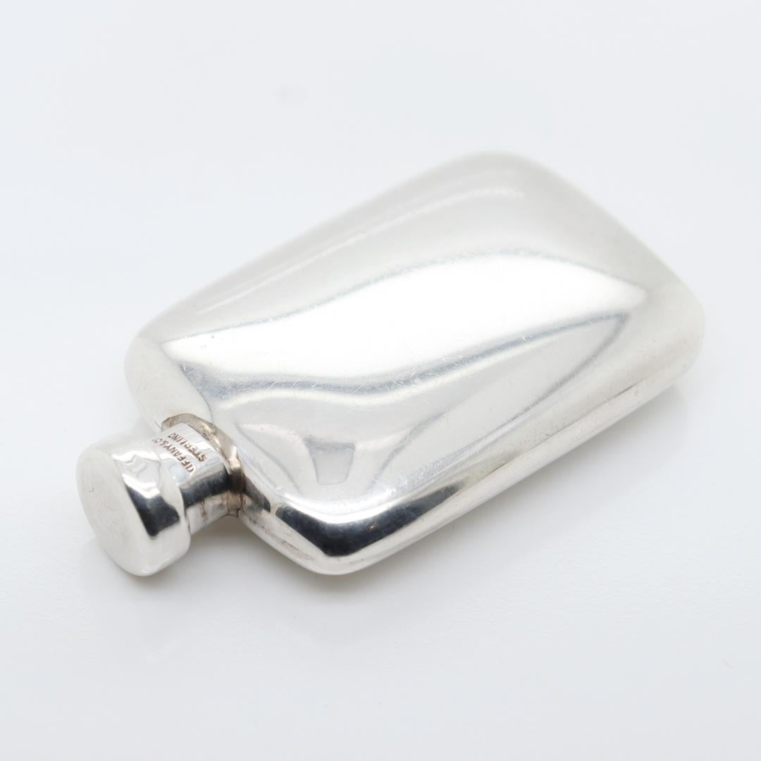 A fine silver miniature perfume flask.

By Tiffany & Co.

In sterling silver.

With an threaded lid that has an applicator stick.

Simply a wonderful miniature perfume bottle from Tiffany!

Date:
20th Century

Overall Condition:
It is in overall