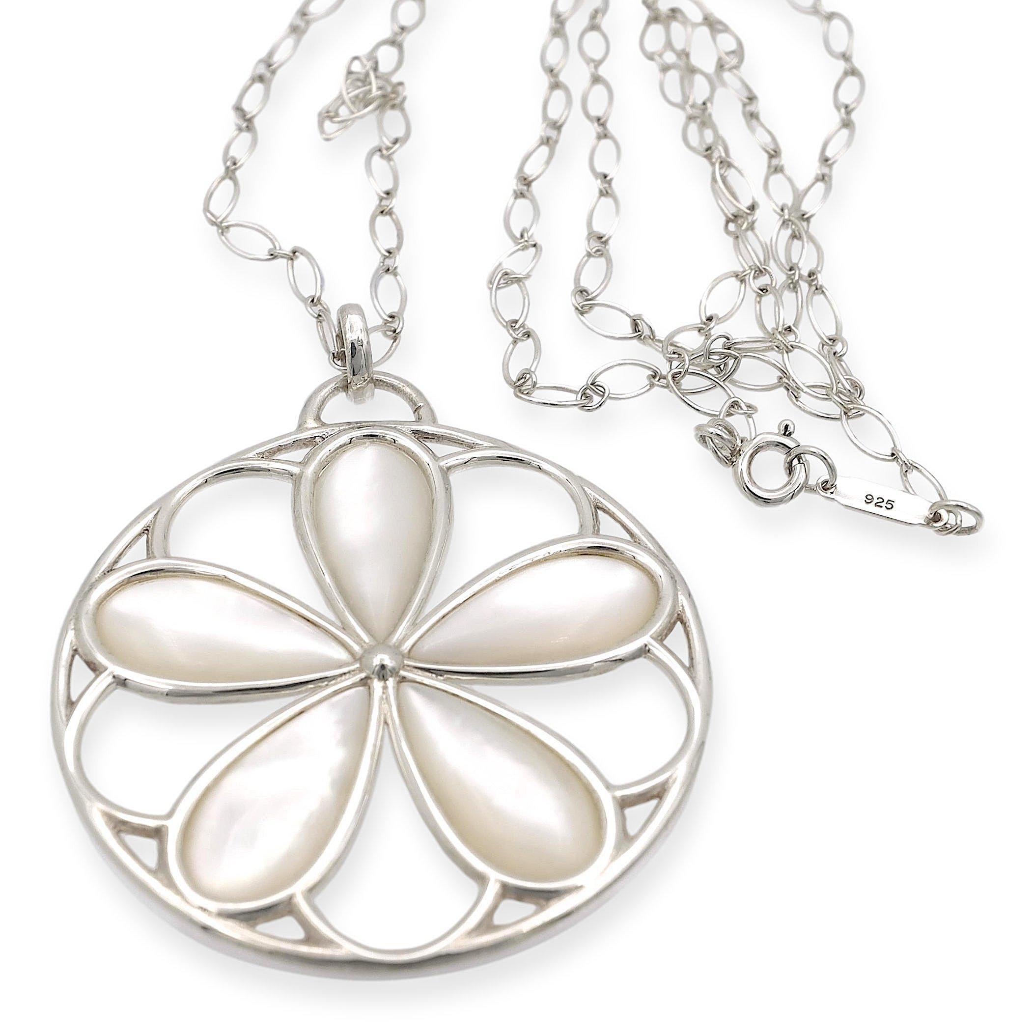 Tiffany & Co. pendant necklace finely crafted in sterling silver featuring an open scroll work daisy flower pendant delicately made with mother of pearl petals inside a round silver wire rim hanging off an oval link 24
