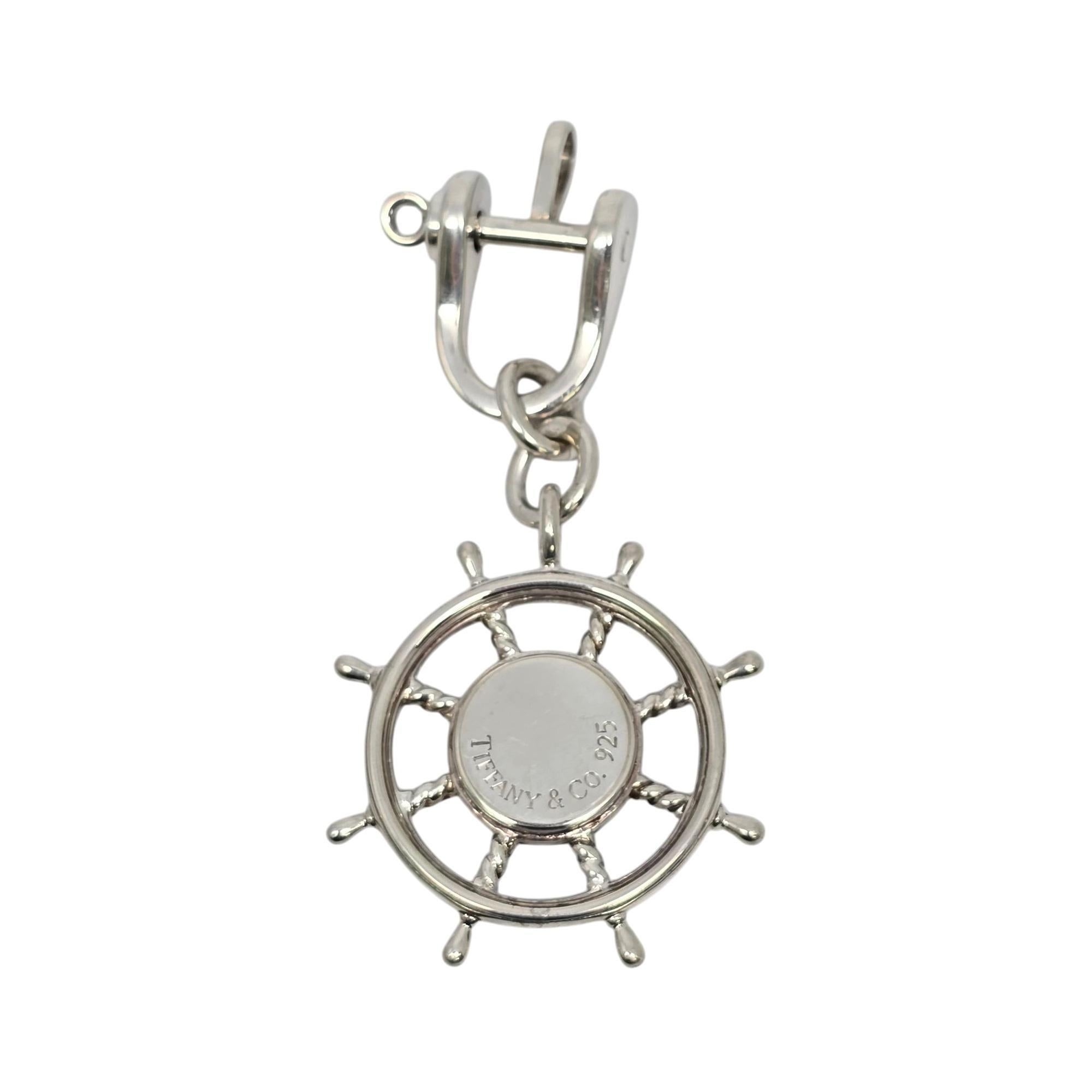 Sterling silver ship wheel compass keychain.

Perfect for the nautical enthusiast, this keychain features a ship wheel with a compass at its center. Tiffany & Co box and pouch are not included.

Measures approx 3 1/2