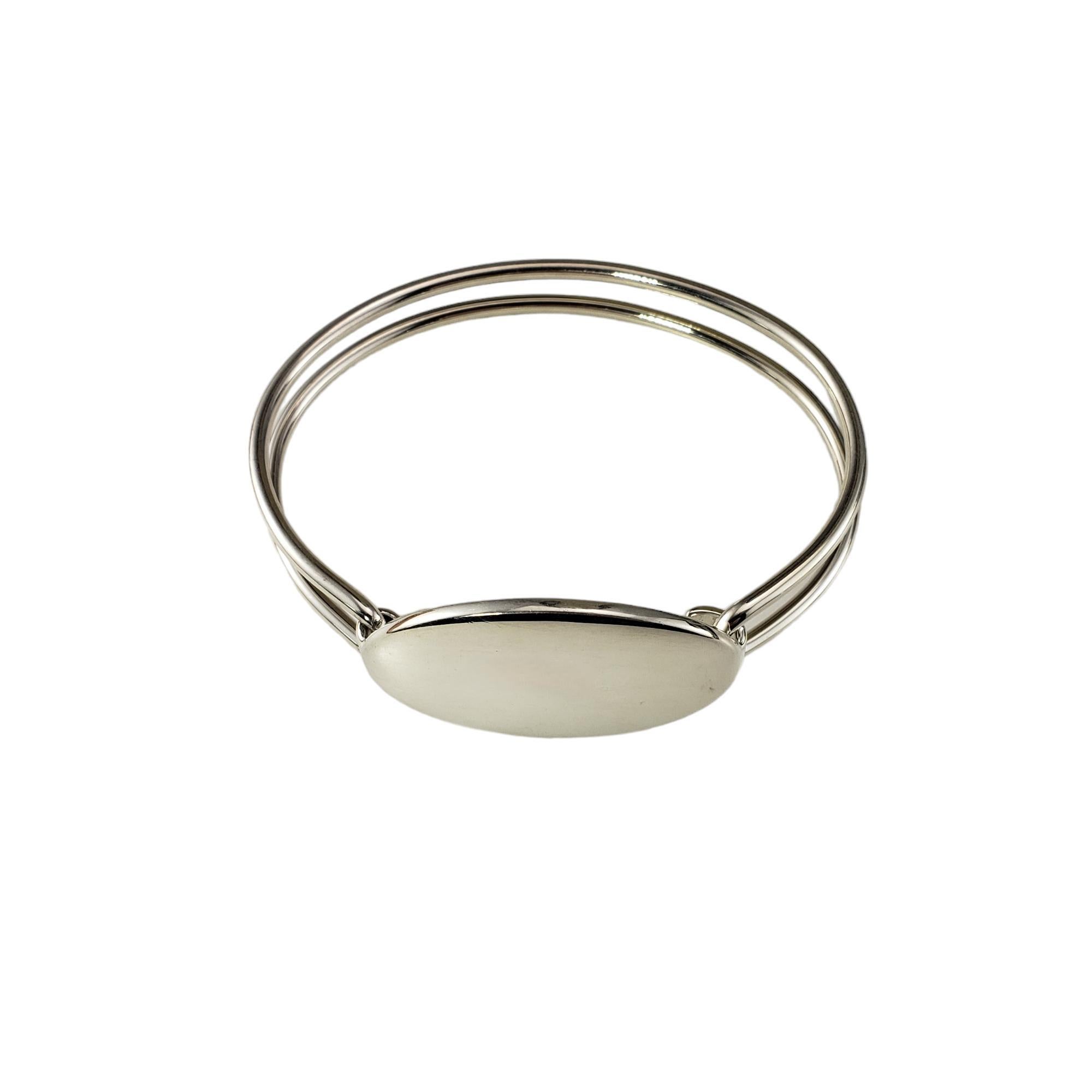 Tiffany & Co. Sterling Silver Oval ID Double Wire Bracelet-

This elegant ID bangle bracelet is crafted in classic sterling silver by Tiffany & Co. ID tag 

Width: 1 inch. Bracelet width: 10 mm.

Matching necklace: #17357

Size: 6.5
