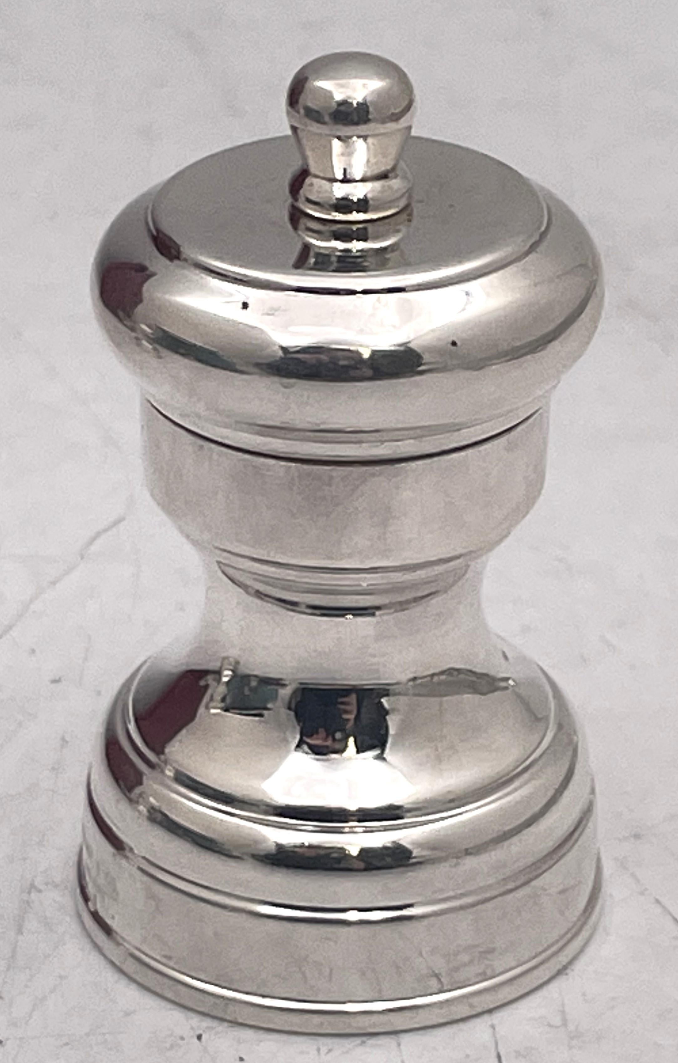 Pair of Tiffany & Co. sterling silver saltshaker and pepper grinder, made in Italy in the 20th century, and in Mid-Century Modern Style, with an elegant, geometric design. The pepper grinder measures 2 1/2'' in height by 1 2/3'' in diameter while
