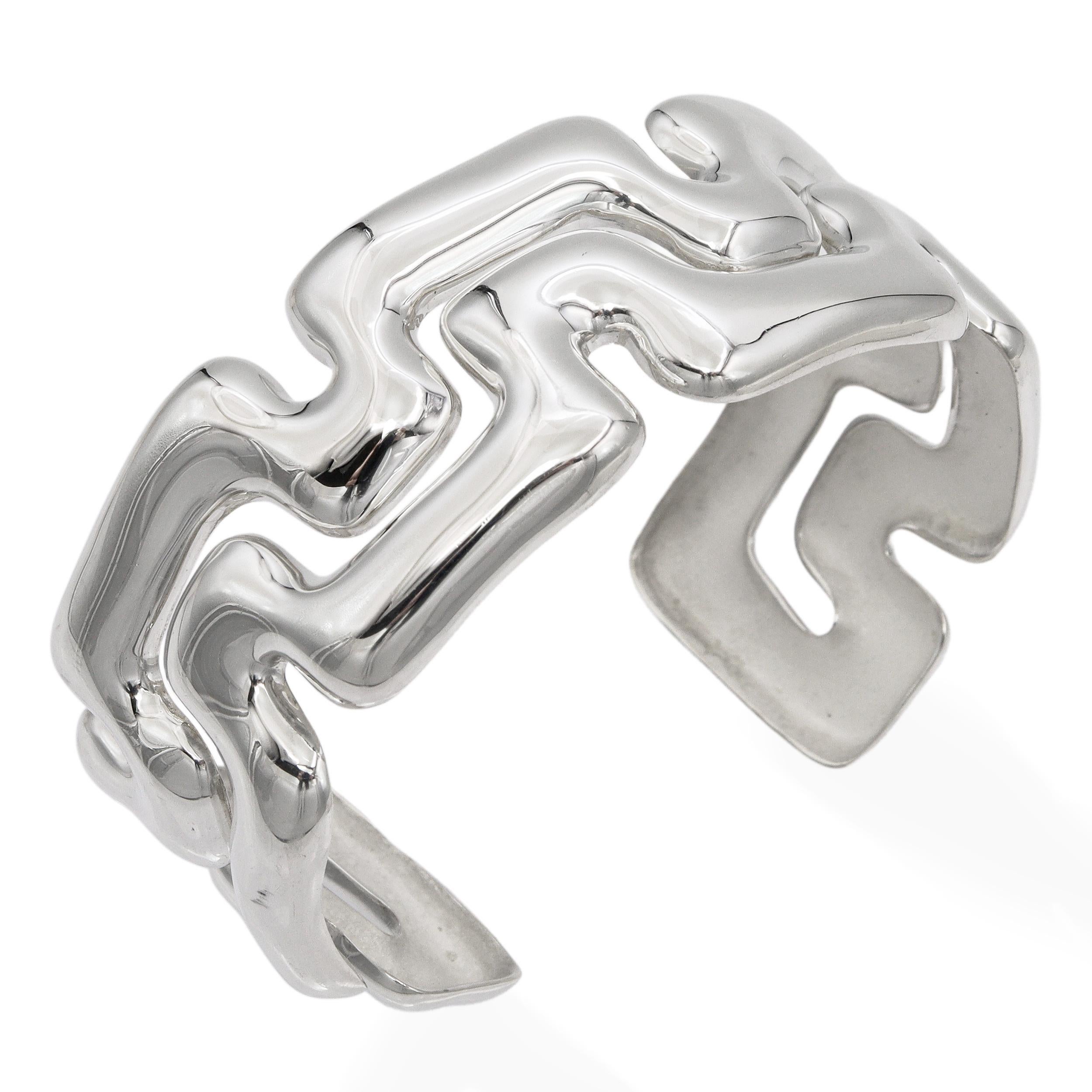 This bold Tiffany & Co. cuff bracelet is crafted from sterling silver (.925) and features the striking Puzzle Greek Key design. The geometric, maze-like pattern creates a sculptural and modern aesthetic while reflecting the timeless inspiration of