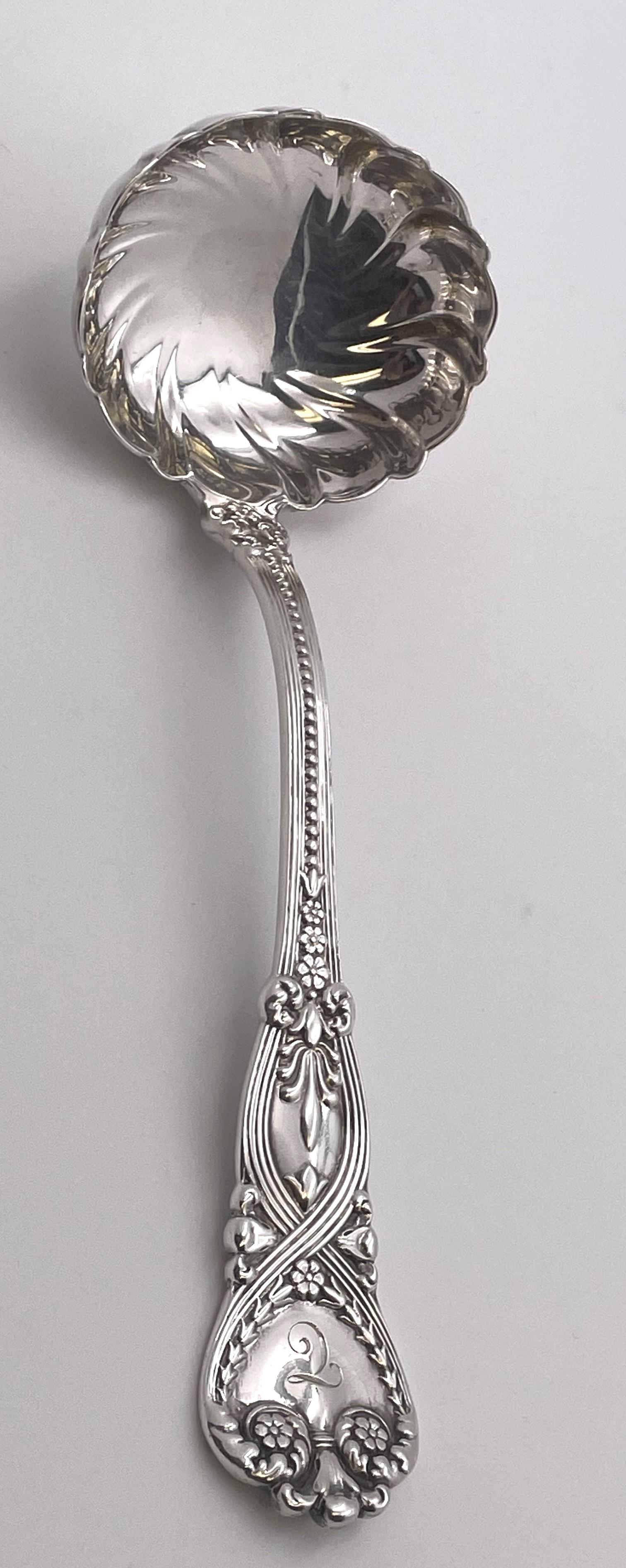 Tiffany & Co. sterling silver scalloped sauce or gravy ladle in the Saint James pattern, beautifully adorned with floral and geometric motifs. It measures 7 1/2'' in length by 2 1/2'' in width, weighs 2.9 troy ounces, and bears hallmarks as