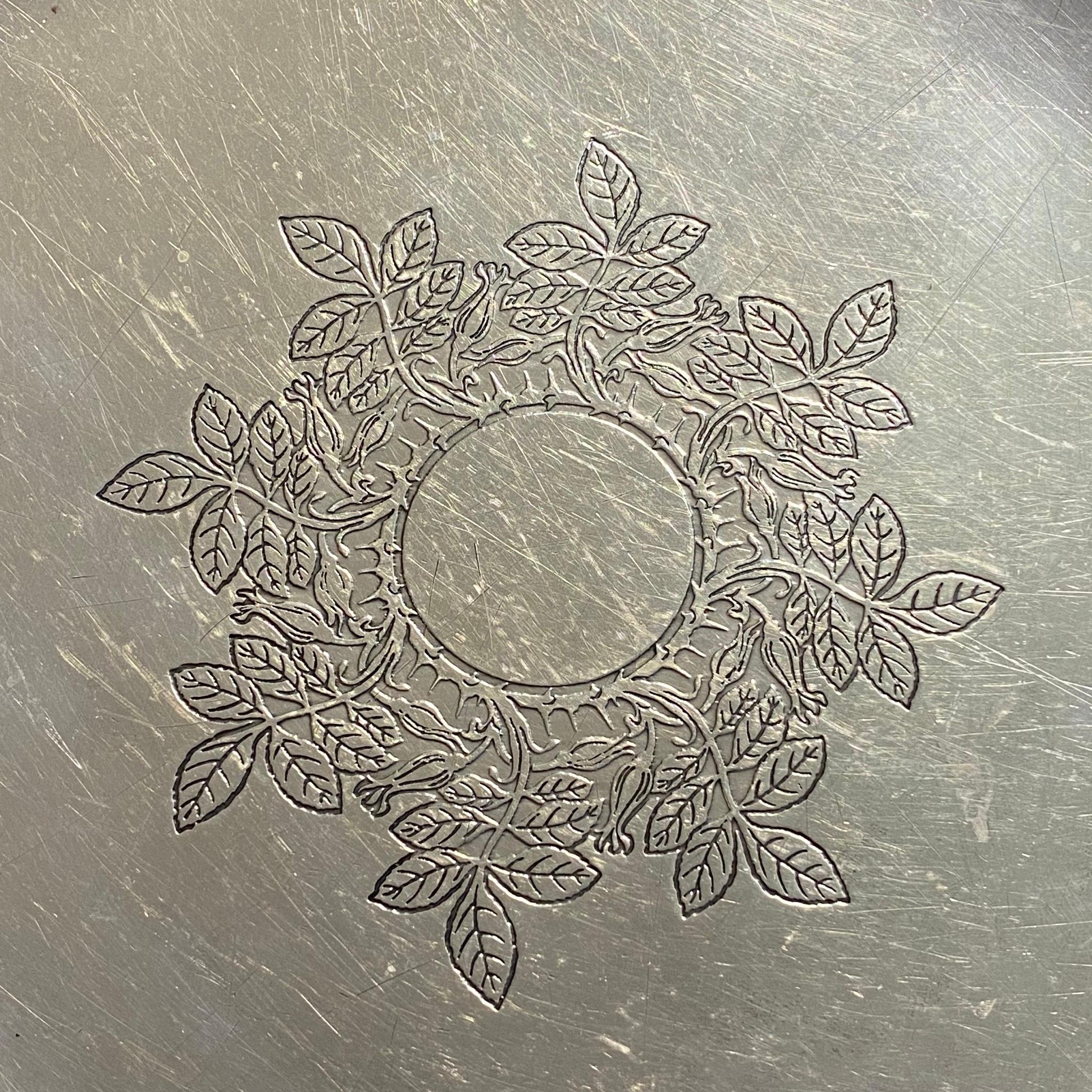 Tiffany & Co. sterling silver serving platter. Center engraved with a floral leaf wreath design. Measuring approximate: 12