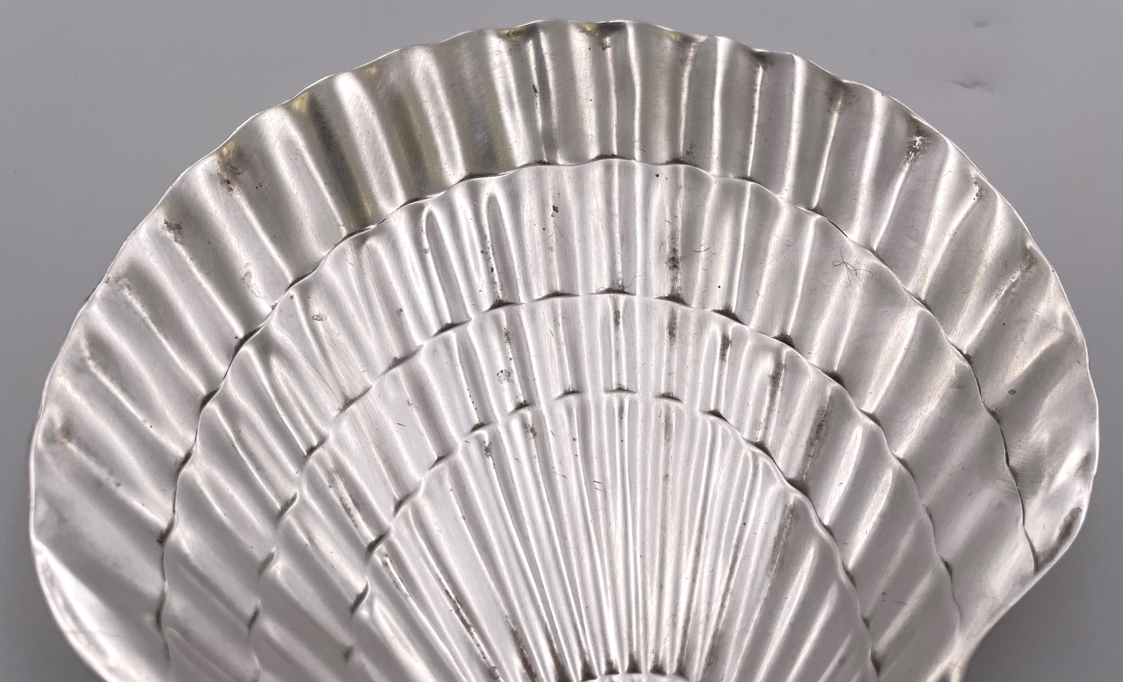 Plato para nueces o caramelos de plata de ley de Tiffany & Co., bellamente modelado en forma de concha con motivos ondulados. Mide 5 3/4'' de fondo por 6'' de ancho y 3/4'' de alto, pesa 6 onzas troy y lleva los sellos que se muestran.

La