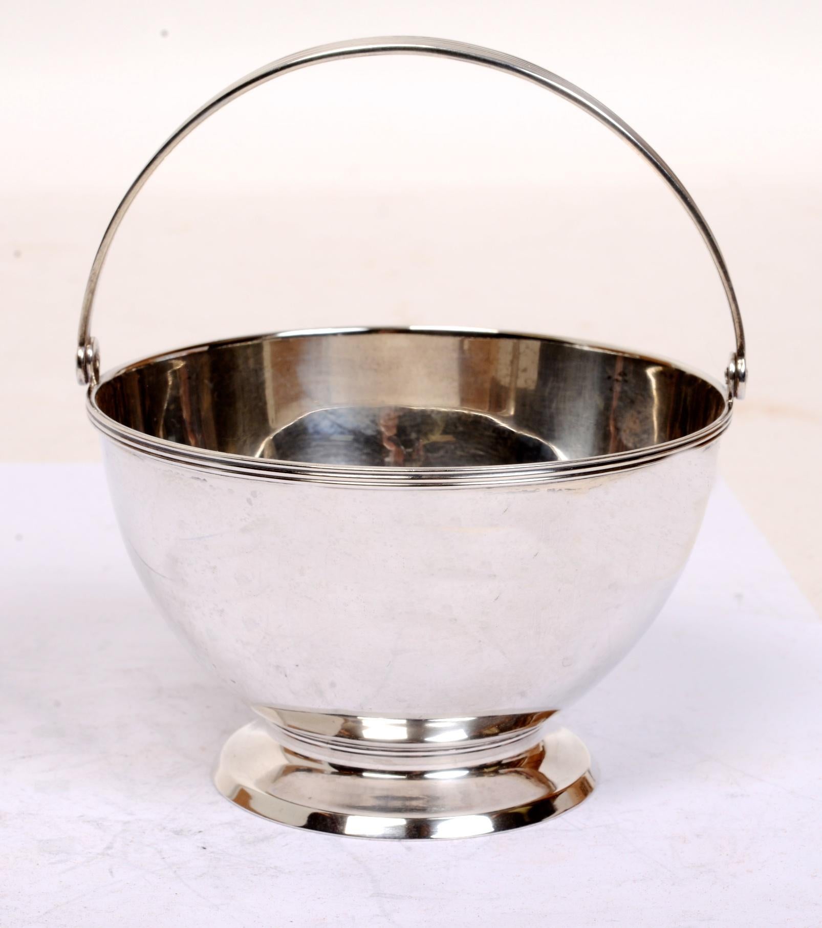 Azucarero con asa oscilante de plata de ley Tiffany & Co. Los sellos del cuenco datan de 1907-1947, cuando John C. MooreII era el presidente. El cuenco tiene una forma sencilla y clásica, con un borde rebordeado alrededor del cuenco y el asa. El
