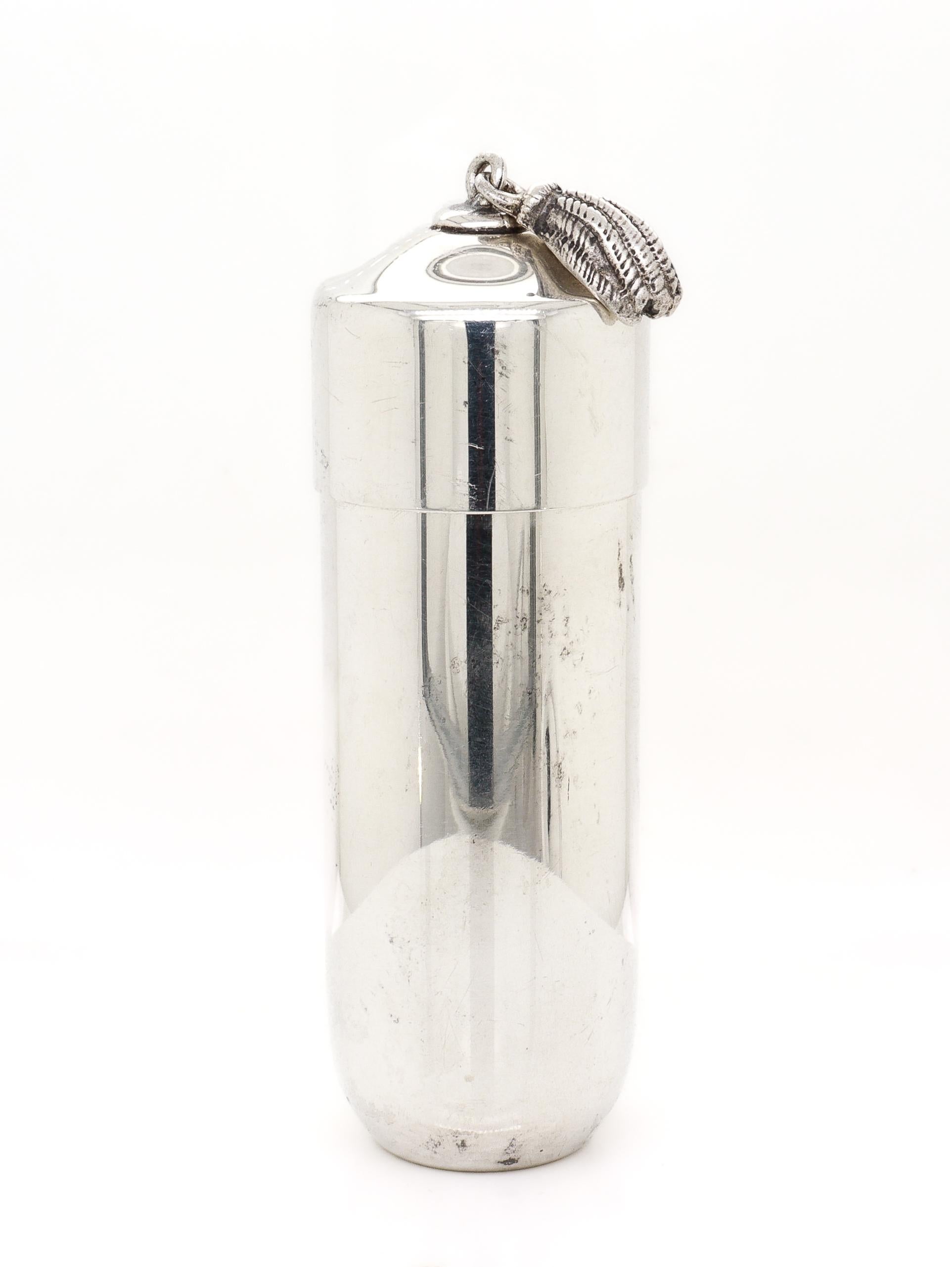 A fine silver portable sewing kit.

In sterling silver.

By Tiffany & Co.

In the form of a cylindrical box. The interior has a central, tube compartment with a removable cap. The compartment has space for needles, and the cap holds 3 steel bobbins