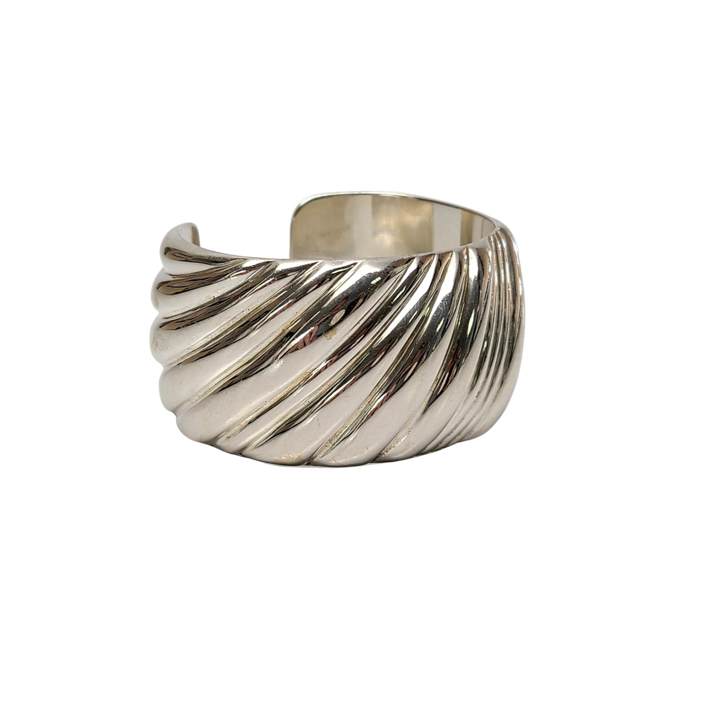 Tiffany & Co sterling silver wide cuff bracelet.

Authentic Tiffany sterling silver bracelet featuring a wave design, a wide and substantial modern vintage piece. Tiffany pouch and box not included.

Measures approx 5