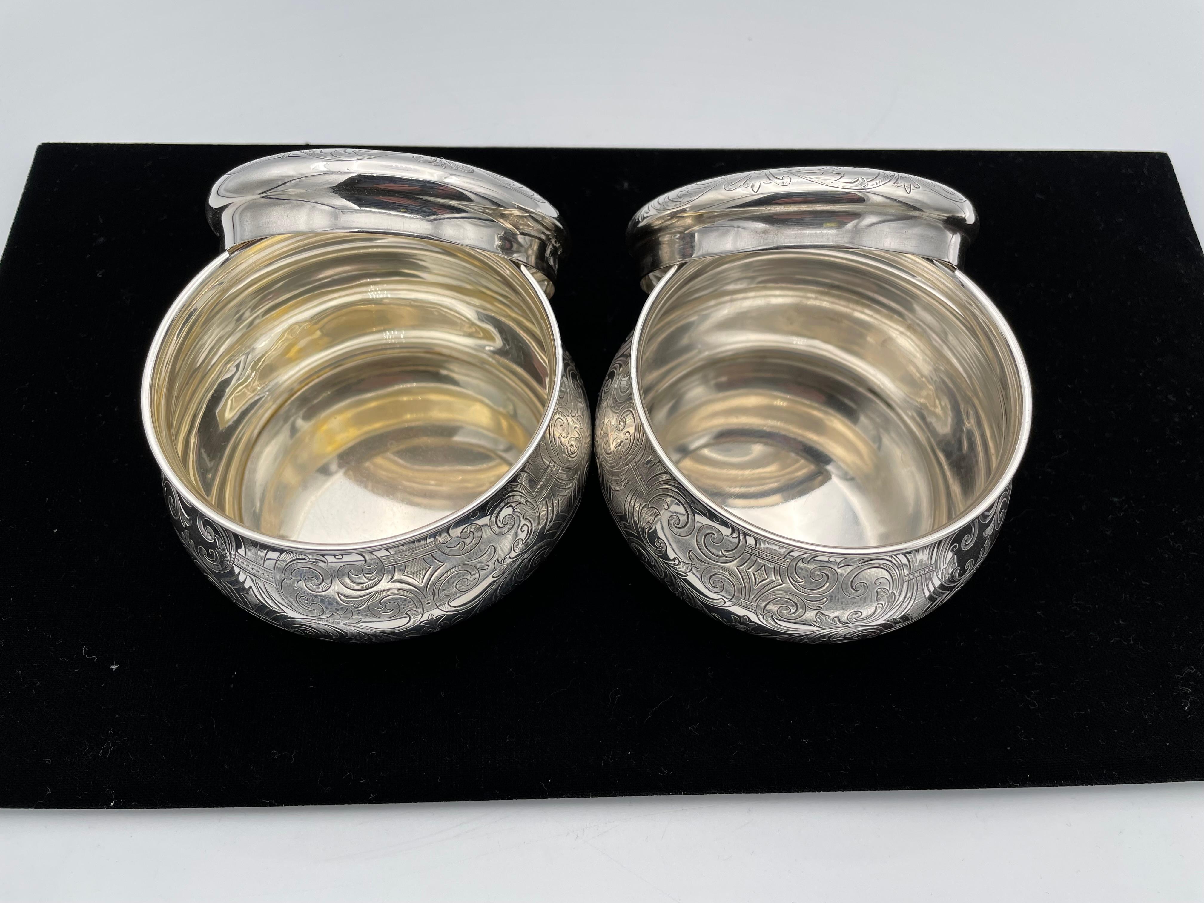 Exquisite pair of large sterling silver vanity jars. Made and signed by TIFFANY & CO. Both jars, one closed and one with an open
top, are gracefully shaped, with small pedestals. Intricate allover deeply engraved pattern. 4