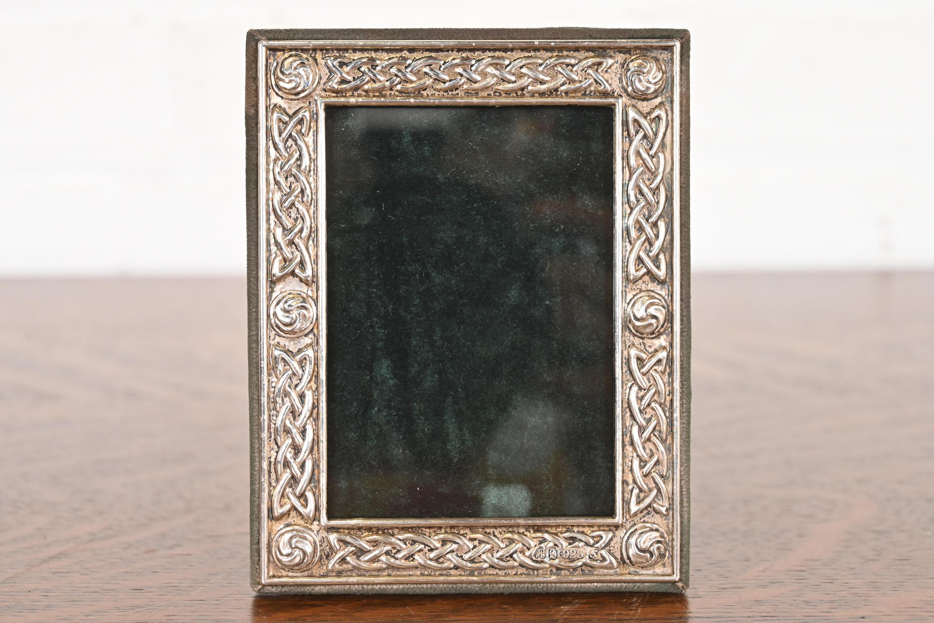 A lovely vintage Celtic knot sterling silver picture frame with green velvet back and liner

In the manner of Tiffany & Co.

England, Circa Late 20th Century

Measures: 3.75
