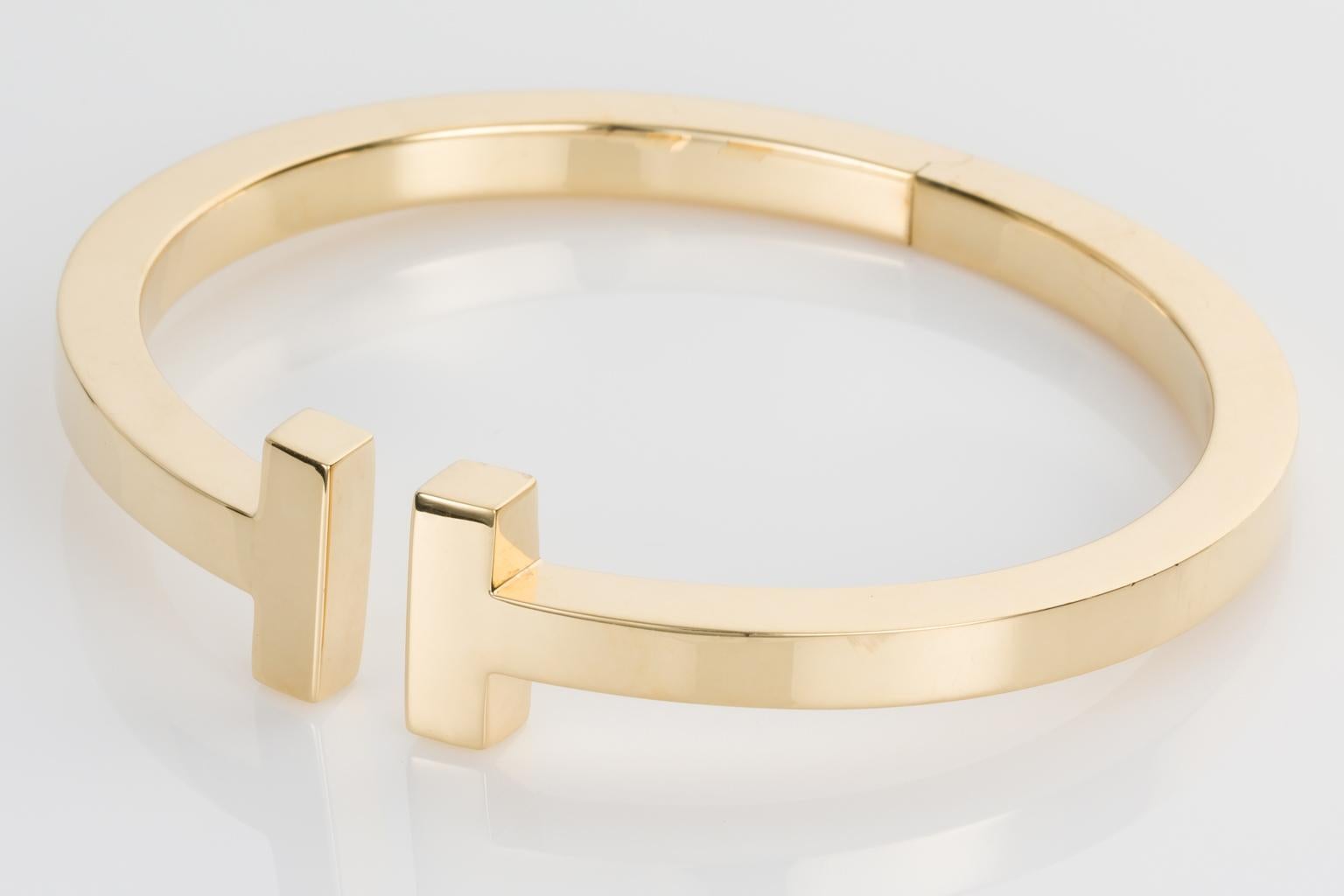 Tiffany & Co T Bangle in high polished 18k Yellow gold. This simplistic style has been extremely popular with many Tiffany collectors adding this bangle to their jewellery wardrobes. This bracelet opening measures 61 x 56mm (2.40 x 2.20 inches) and