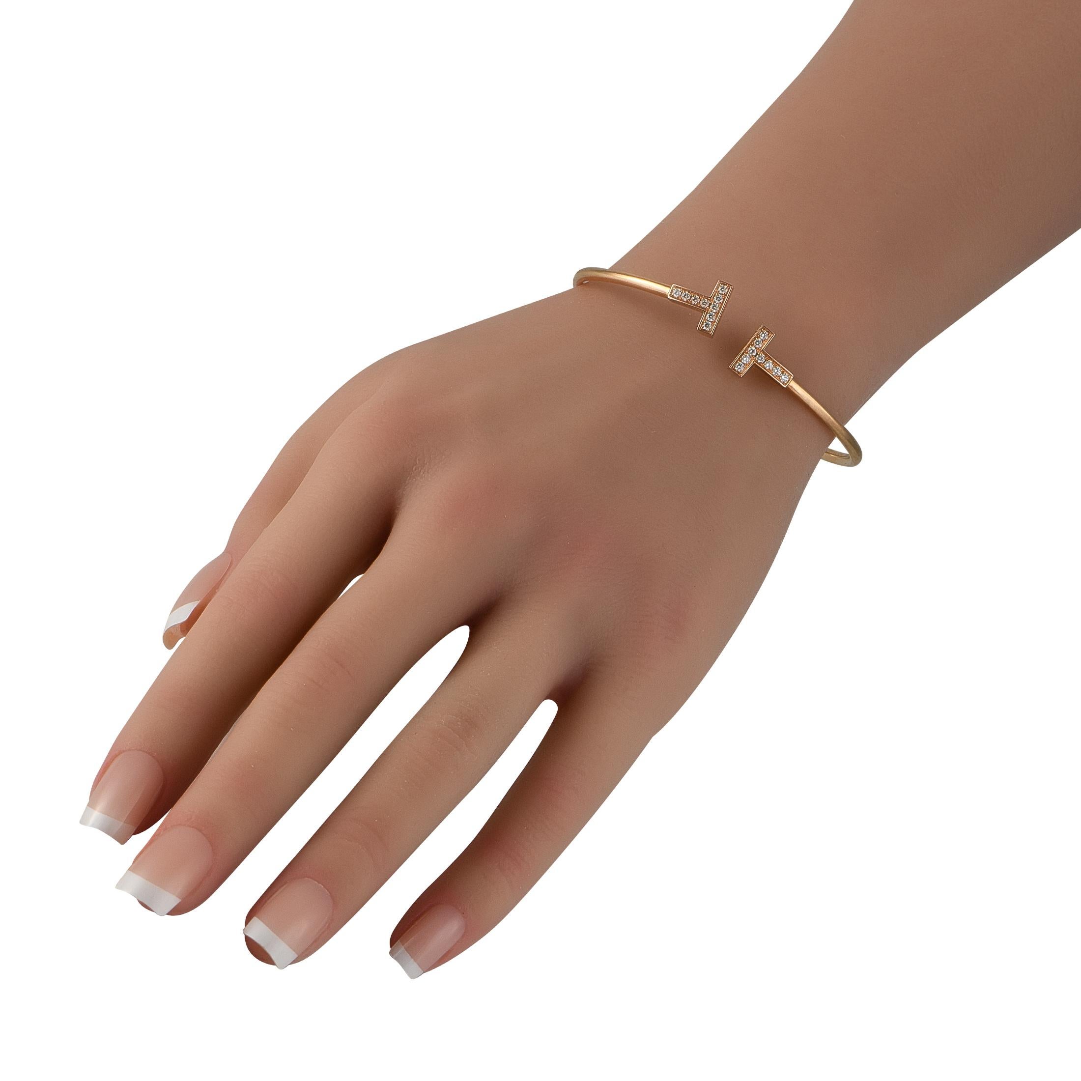Questa Tiffany & Co. Il bracciale bangle Tiffany T possiede un senso di raffinatezza senza tempo. Ispirato a uno dei pezzi d'archivio del marchio, questo bracciale con filo di Tiffany T prende vita grazie ai diamanti incastonati per un peso totale