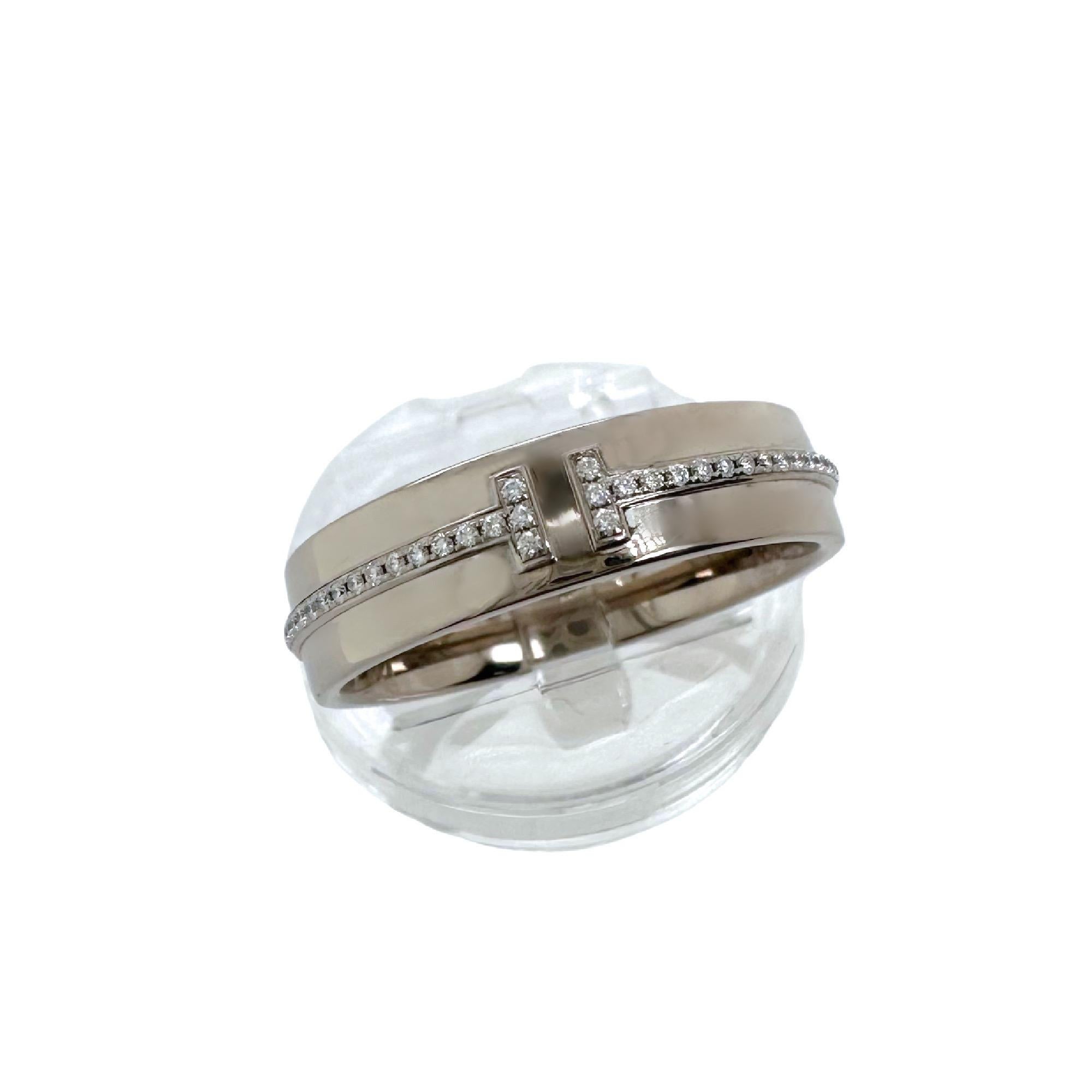 Tiffany & Co. T Collection Diamond Band Ring
Style:  Band
Ref. number:  60150916
Metal:   18kt White Gold Rhodium Plated for Brilliance
Size:  9.75 
Measurements:  5.5 MM 
Main Diamond:  76 Round Brilliant Diamond 0.12 tcw
Color & Clarity:  White &