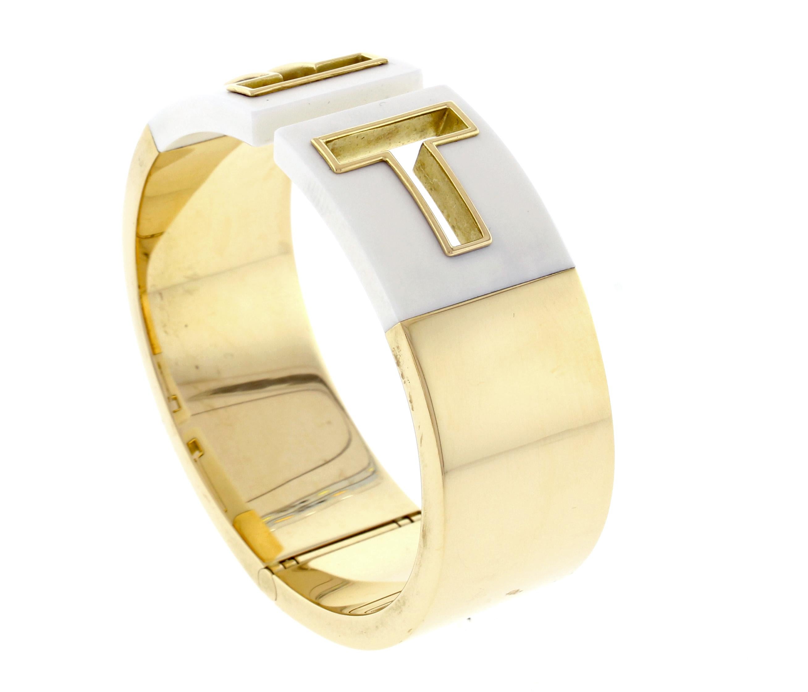 Graphic angles and clean lines blend to create the beautiful clarity of the Tiffany T collection. This sophisticated cuff shines with subtle elegance. 18 karat gold with white ceramic. Medium size, fits up to a 6¼ wrist