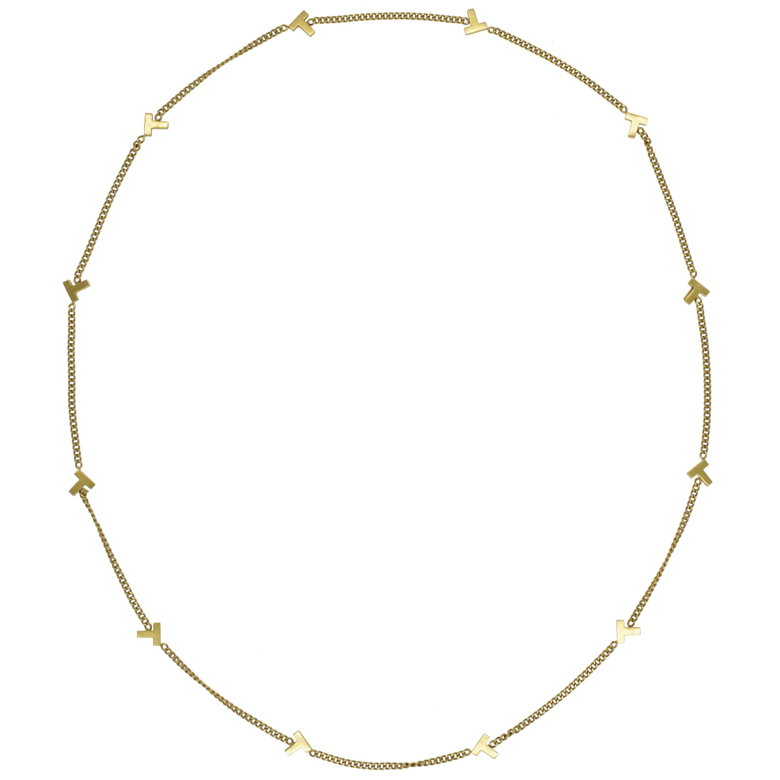 Tiffany & Co. 'T' Long Chain Necklace In 18k Yellow Gold. The
necklace features curb link chain with 12 stationary 'T' motifs
evenly spaced on the chain. Inscribed:
T&Co, 750. Length: 26 inches. Charms measurements: 7mm
by 7mm. Chain width: 2.3mm.